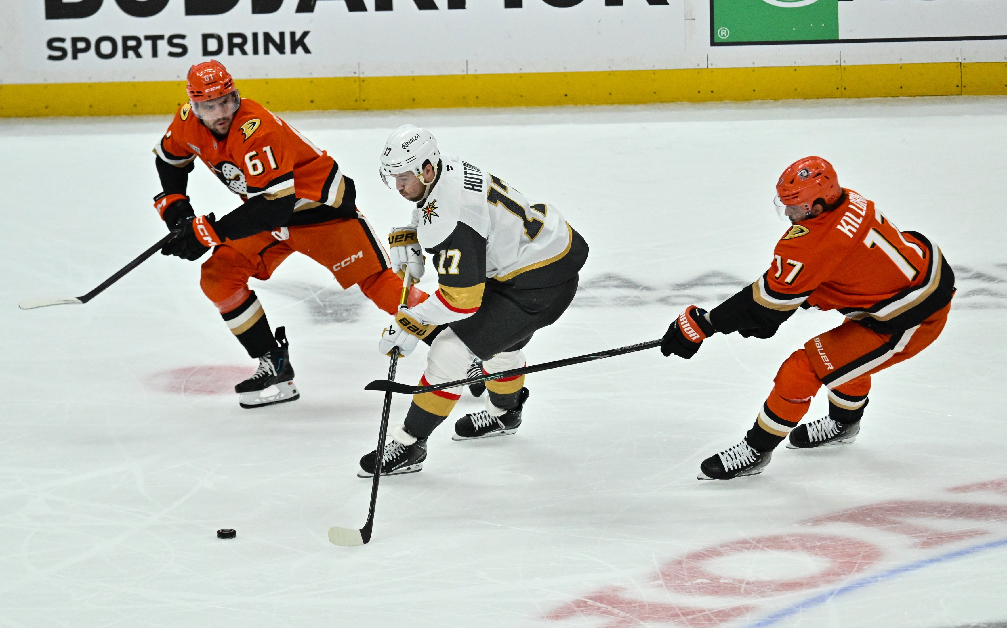 The Vegas Golden Knights’ Ben Hutton, center, controls the puck...
