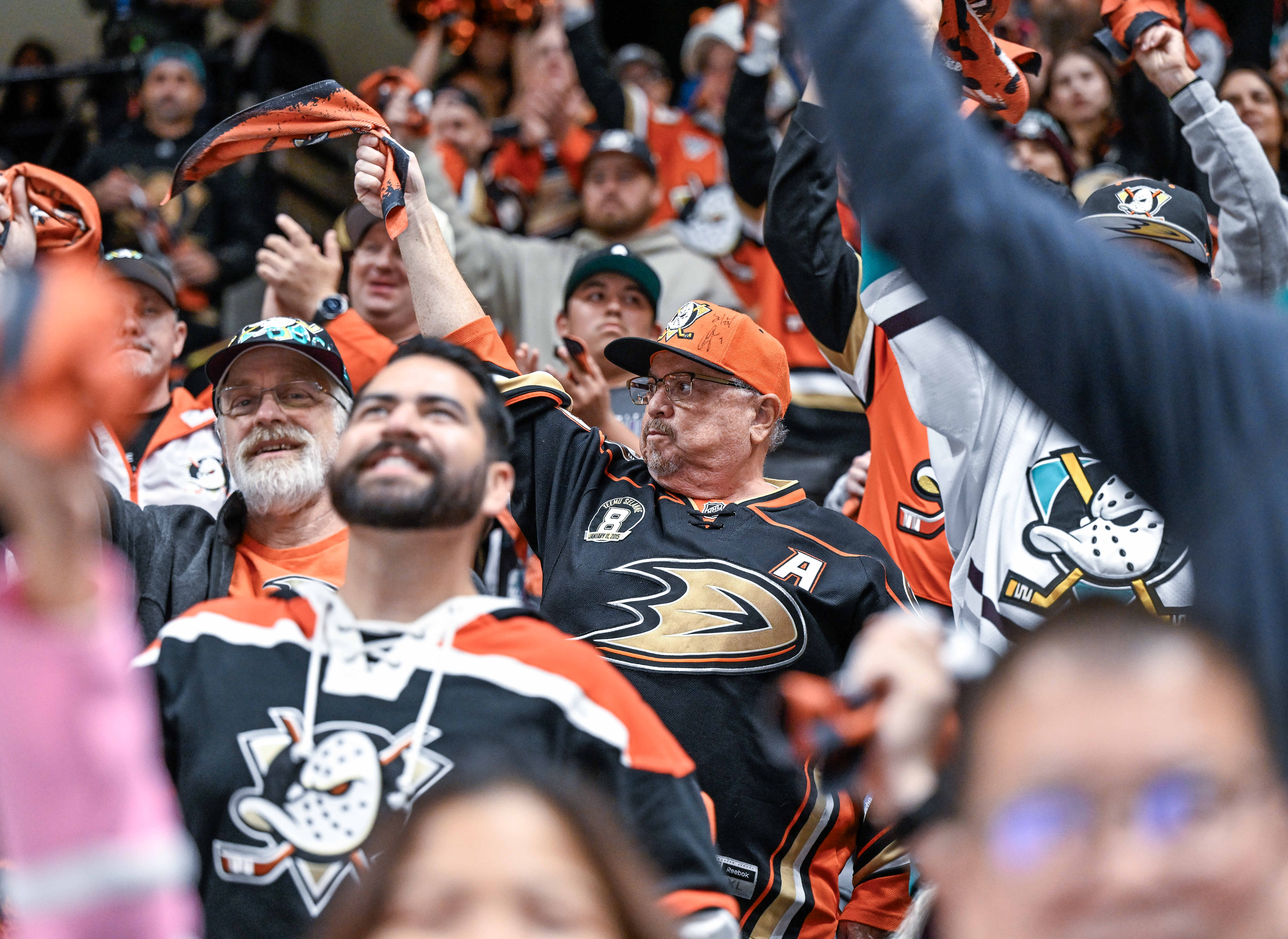 Ducks fans wave towels in the air as they chant...