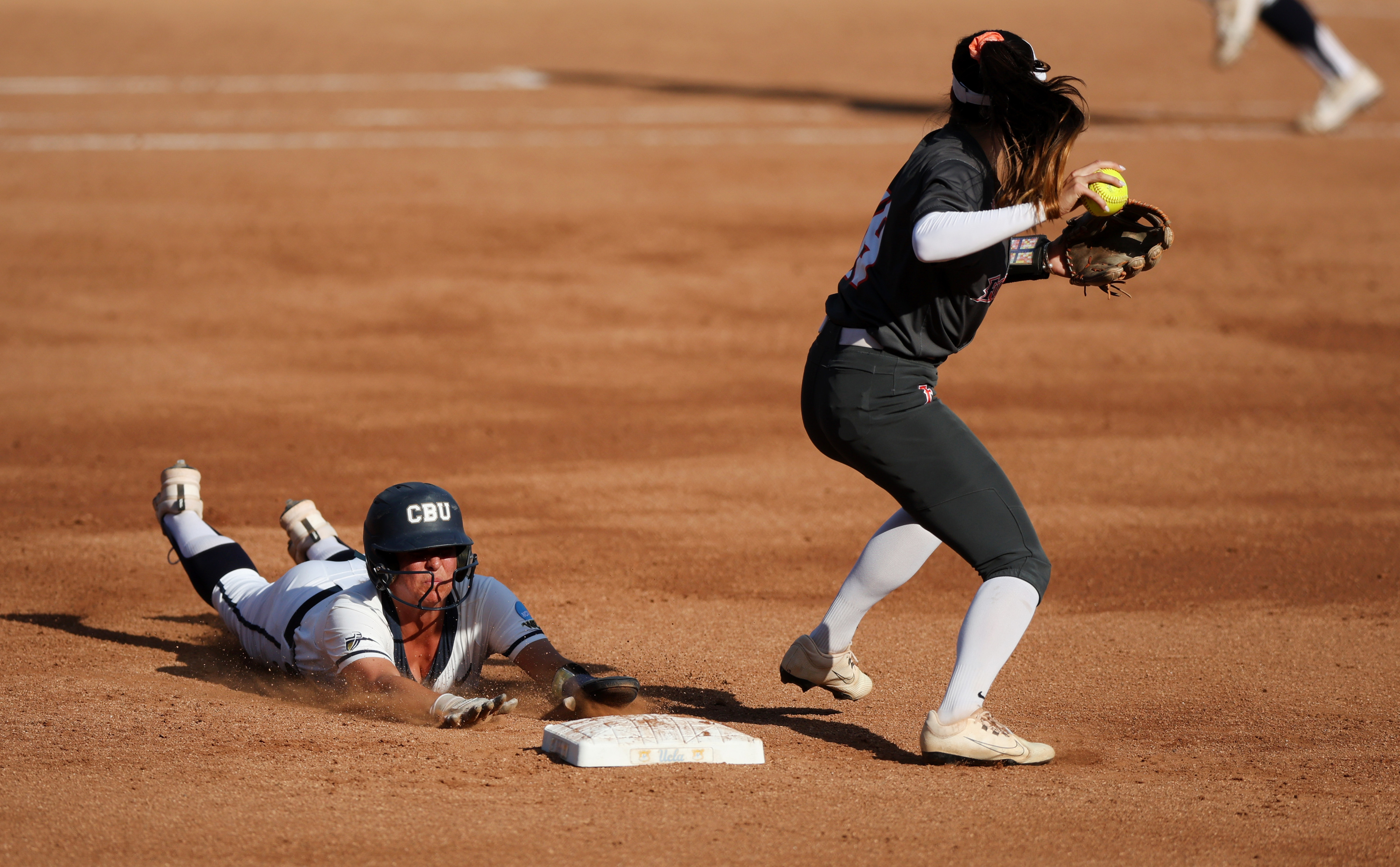 California Baptistâs Ashlee Annett, left, is late with the slide...