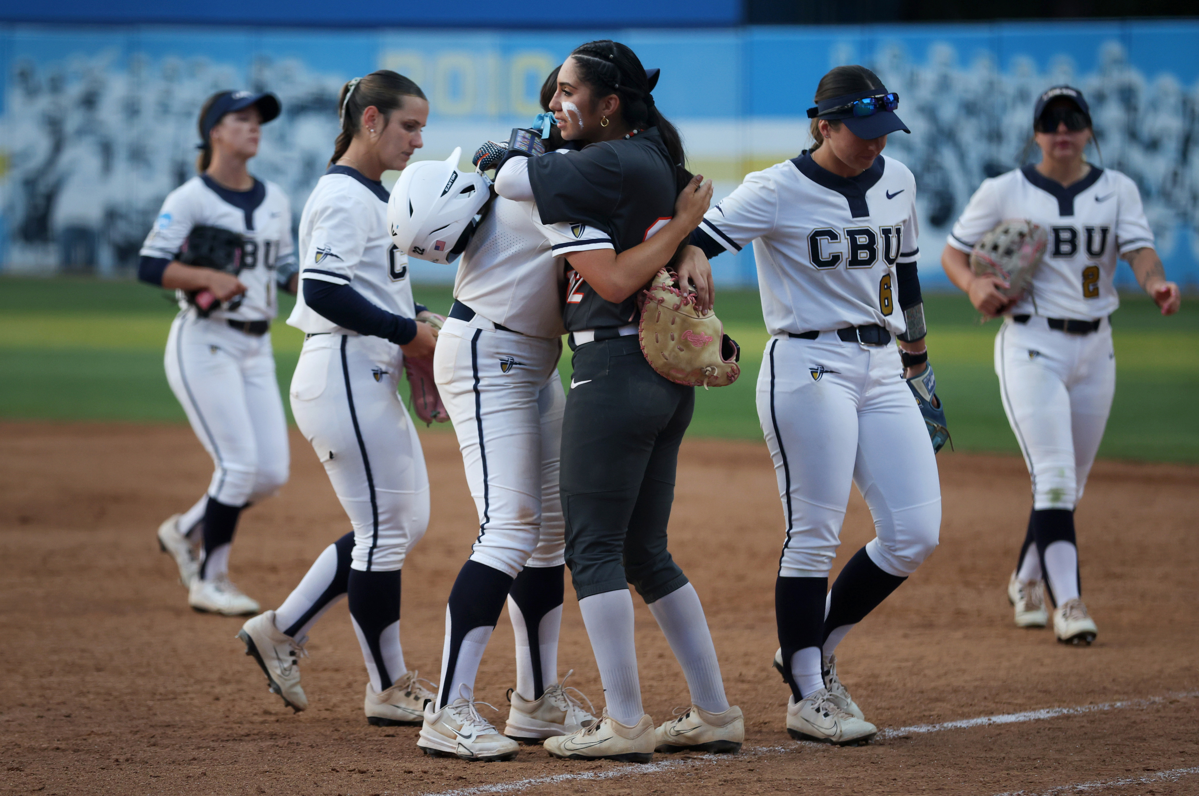 Cal State Fullertonâs Alexia Lopez, center right, embraces Ashlee Annett,...