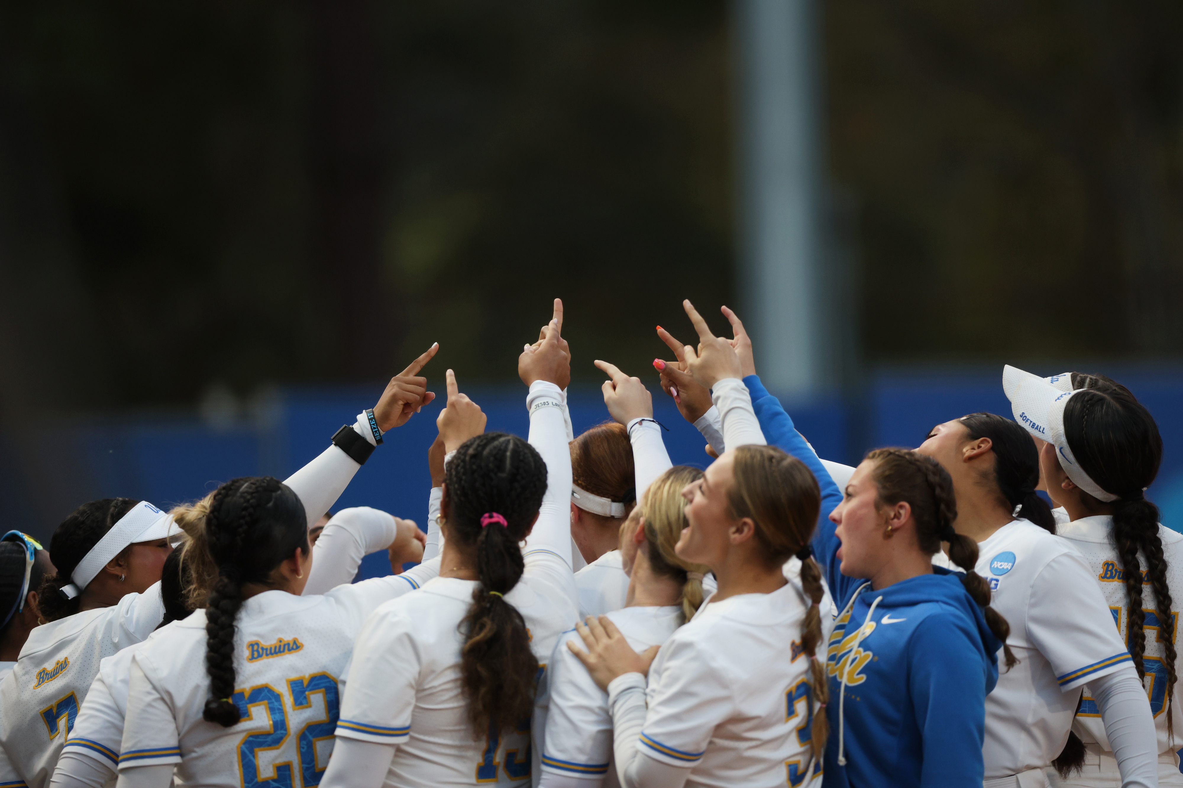 UCLA softball players huddle together before their NCAA Los Angeles...