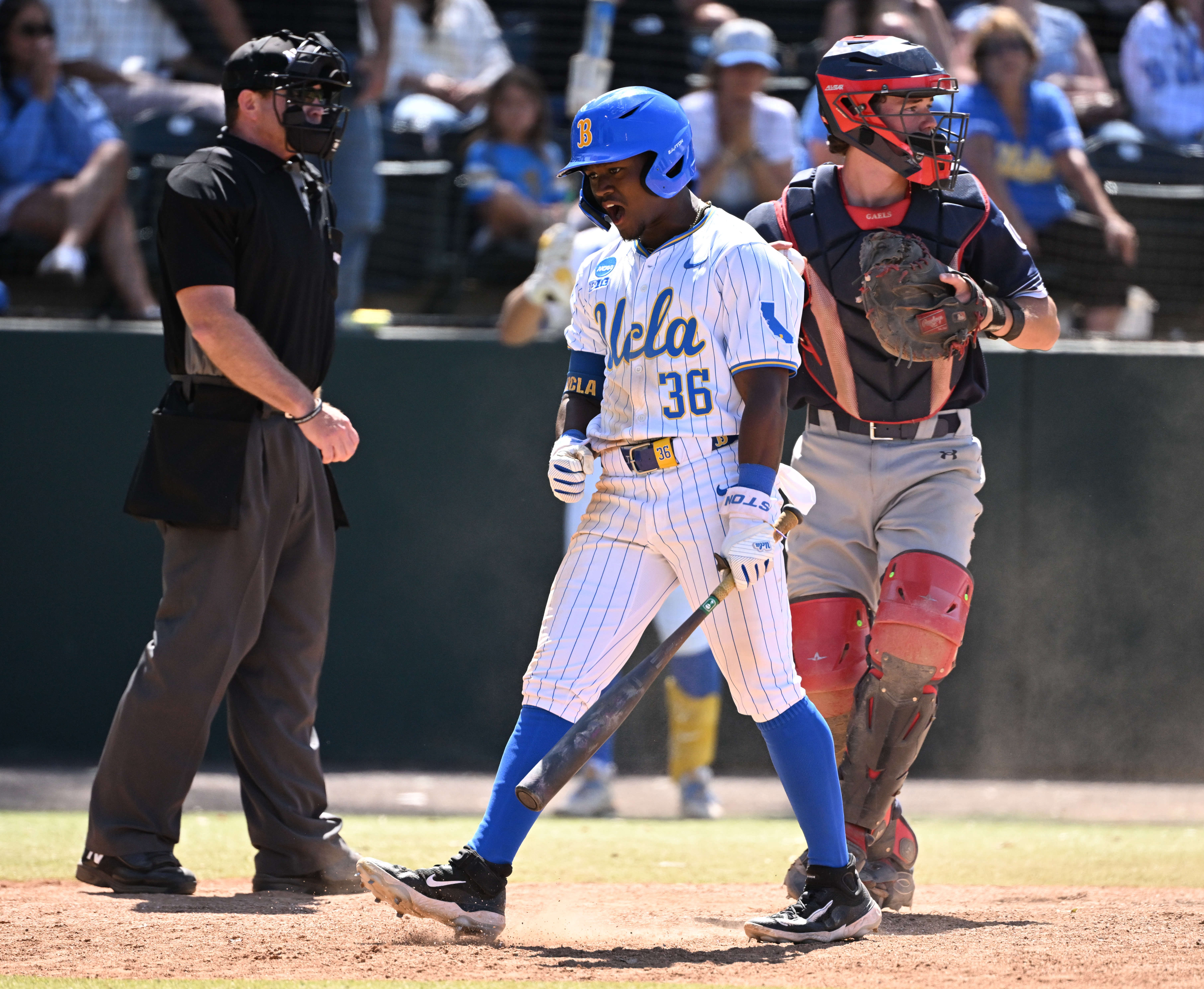 Dean West #36 of the UCLA Bruins reacts after striking...