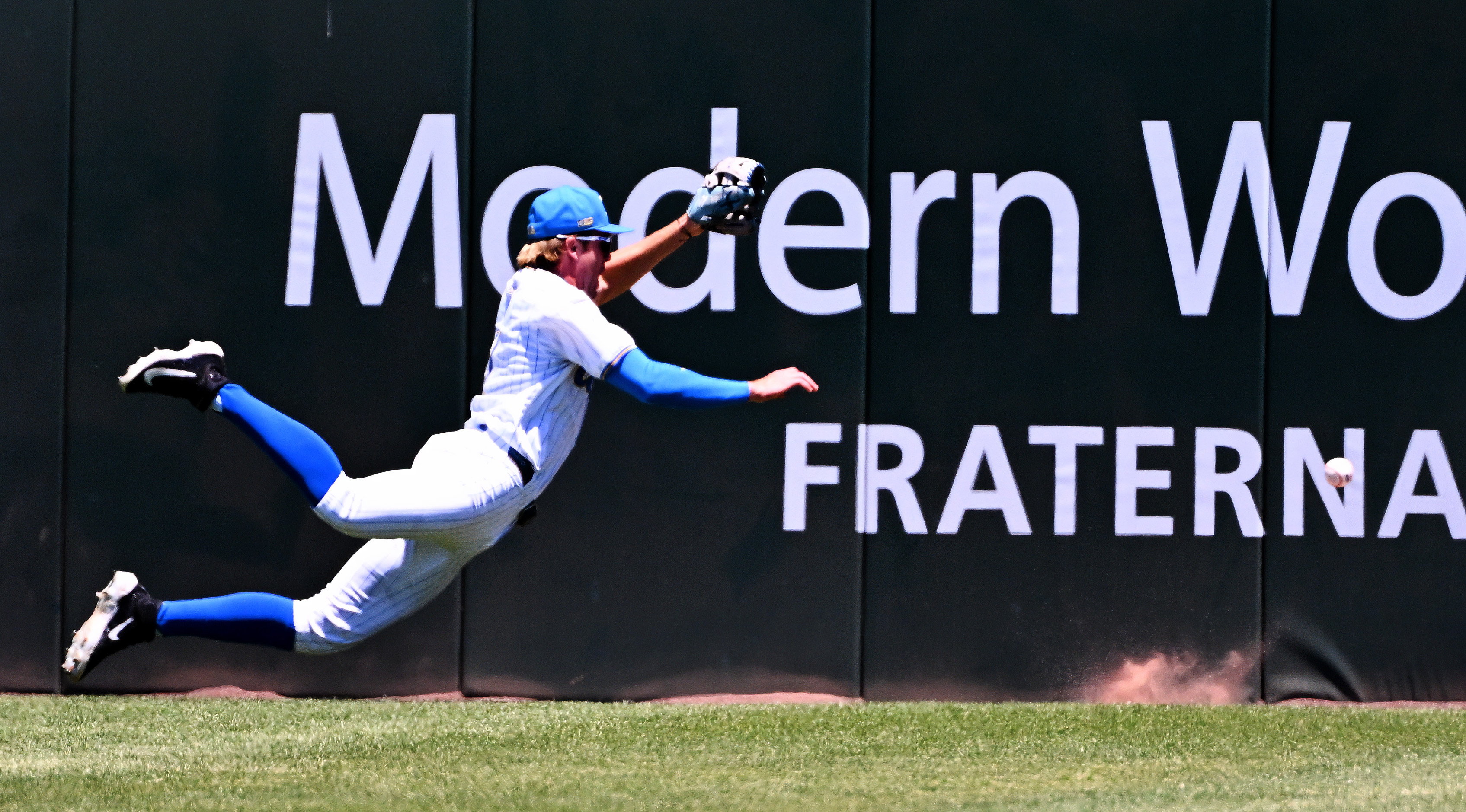 Center fielder Payton Brennan #11 of the UCLA Bruins dives...