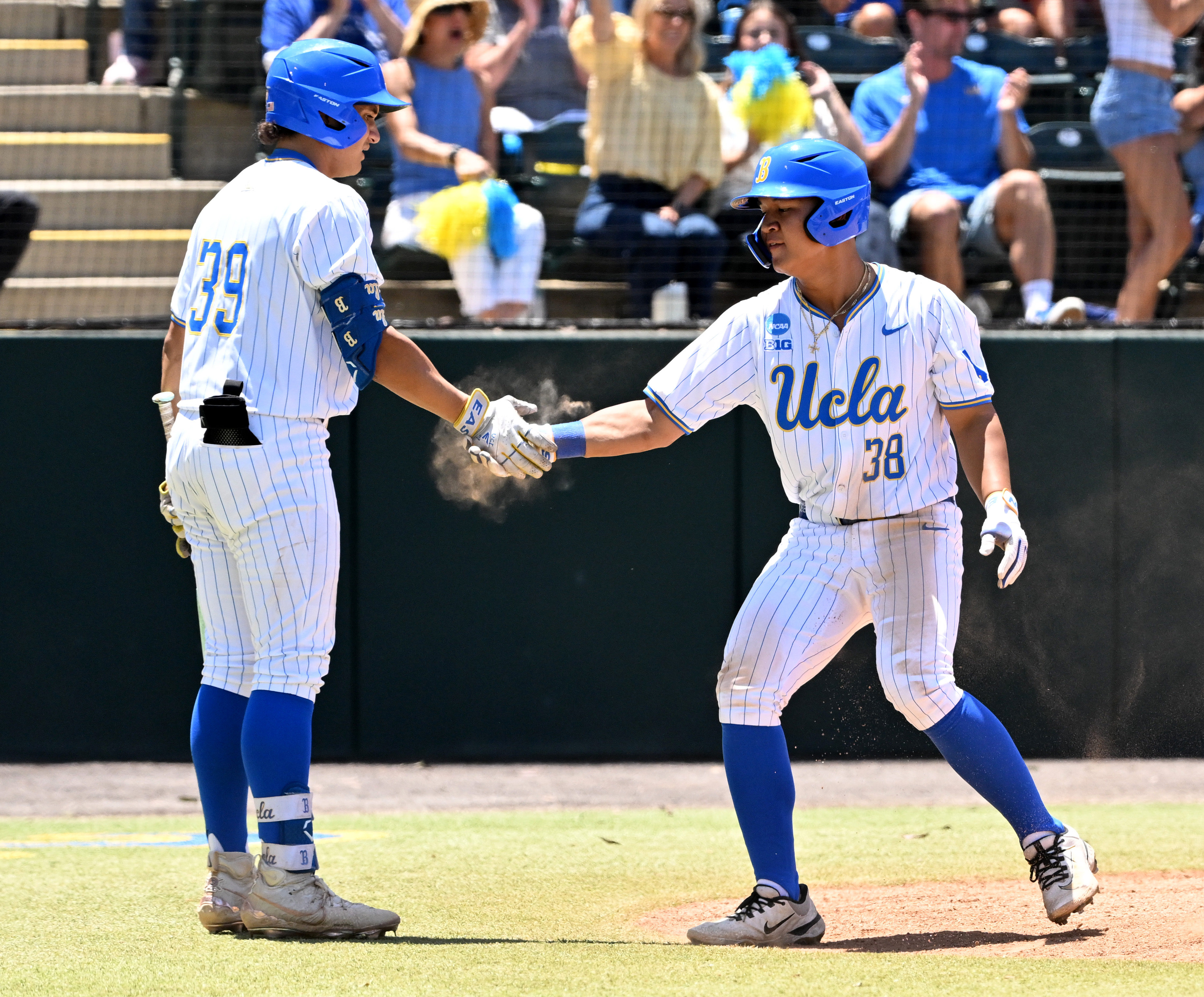 Trey Gudoy #38 of the UCLA Bruins high fives teammate...