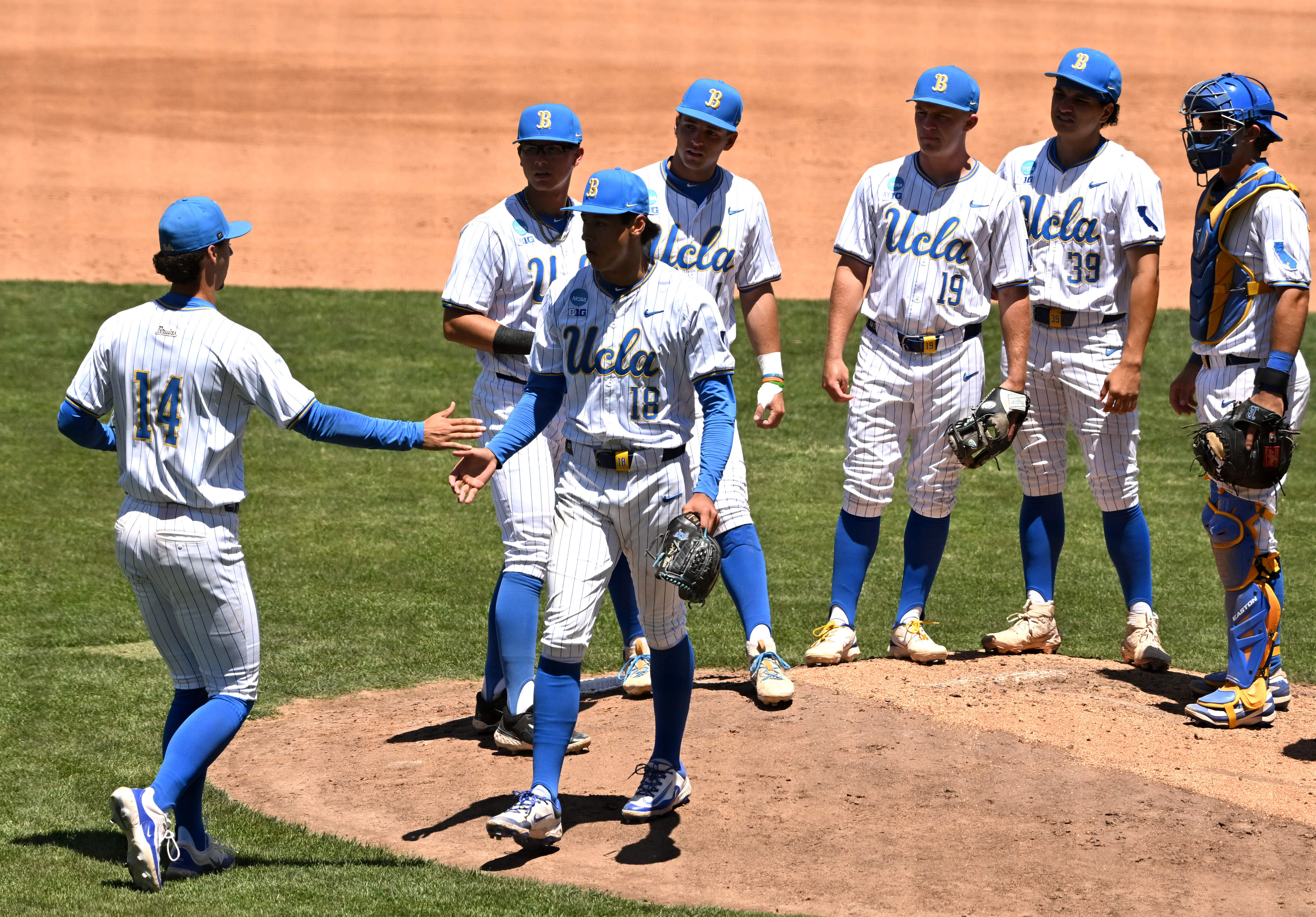 Starting pitcher Wylan Moss #18 of the UCLA Bruins leaves...