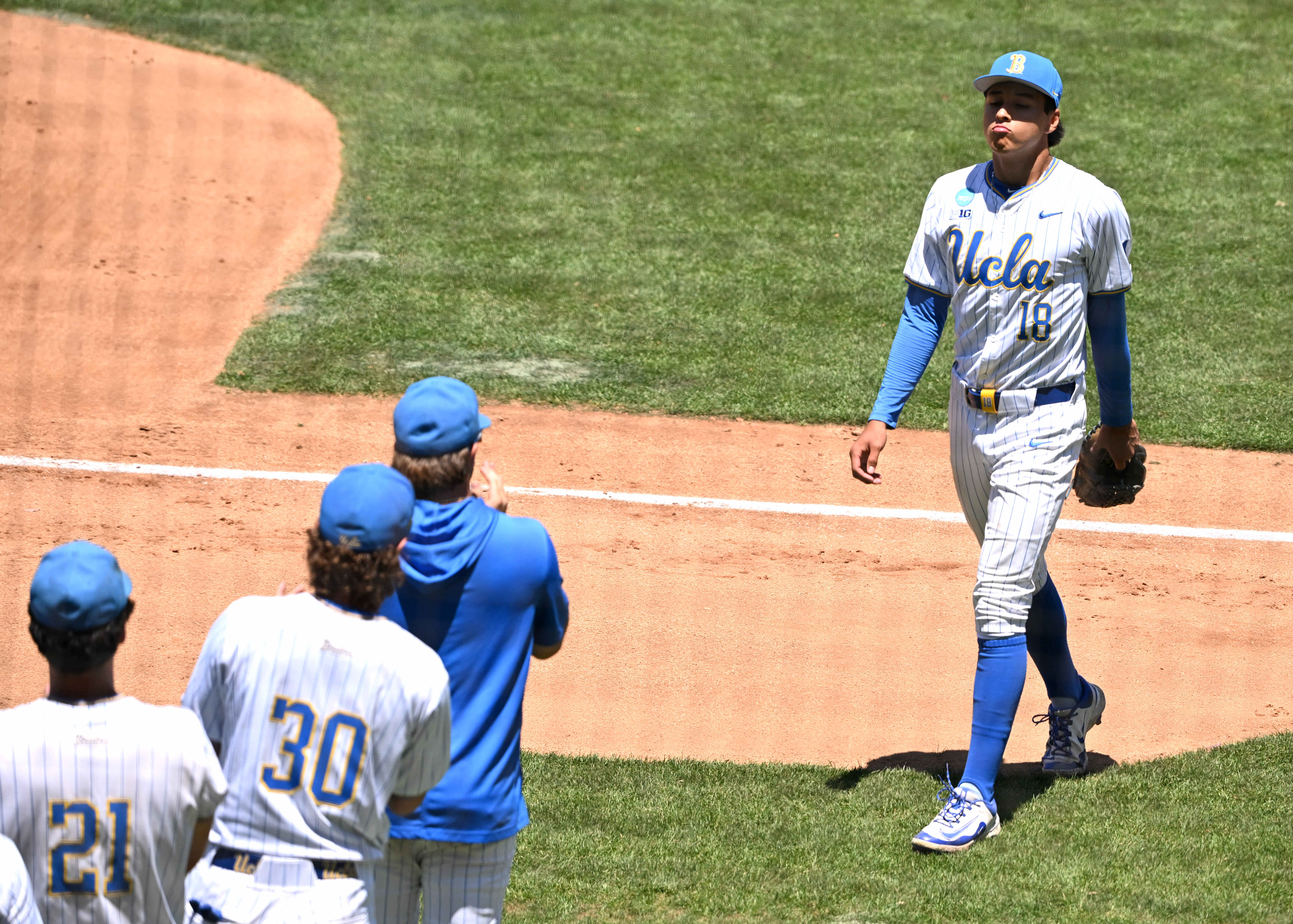 Starting pitcher Wylan Moss #18 of the UCLA Bruins leaves...
