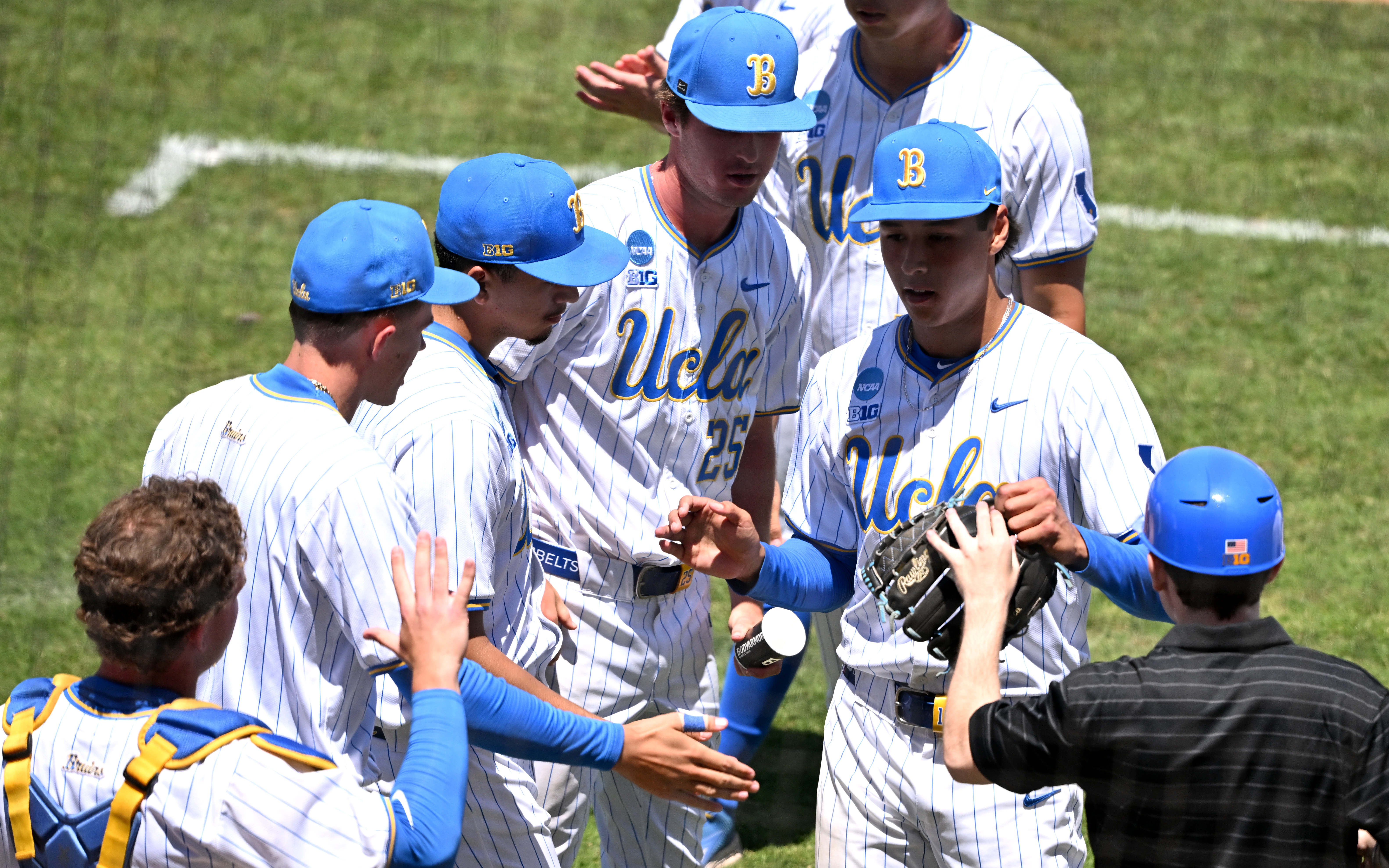 Starting pitcher Wylan Moss #18 of the UCLA Bruins leaves...