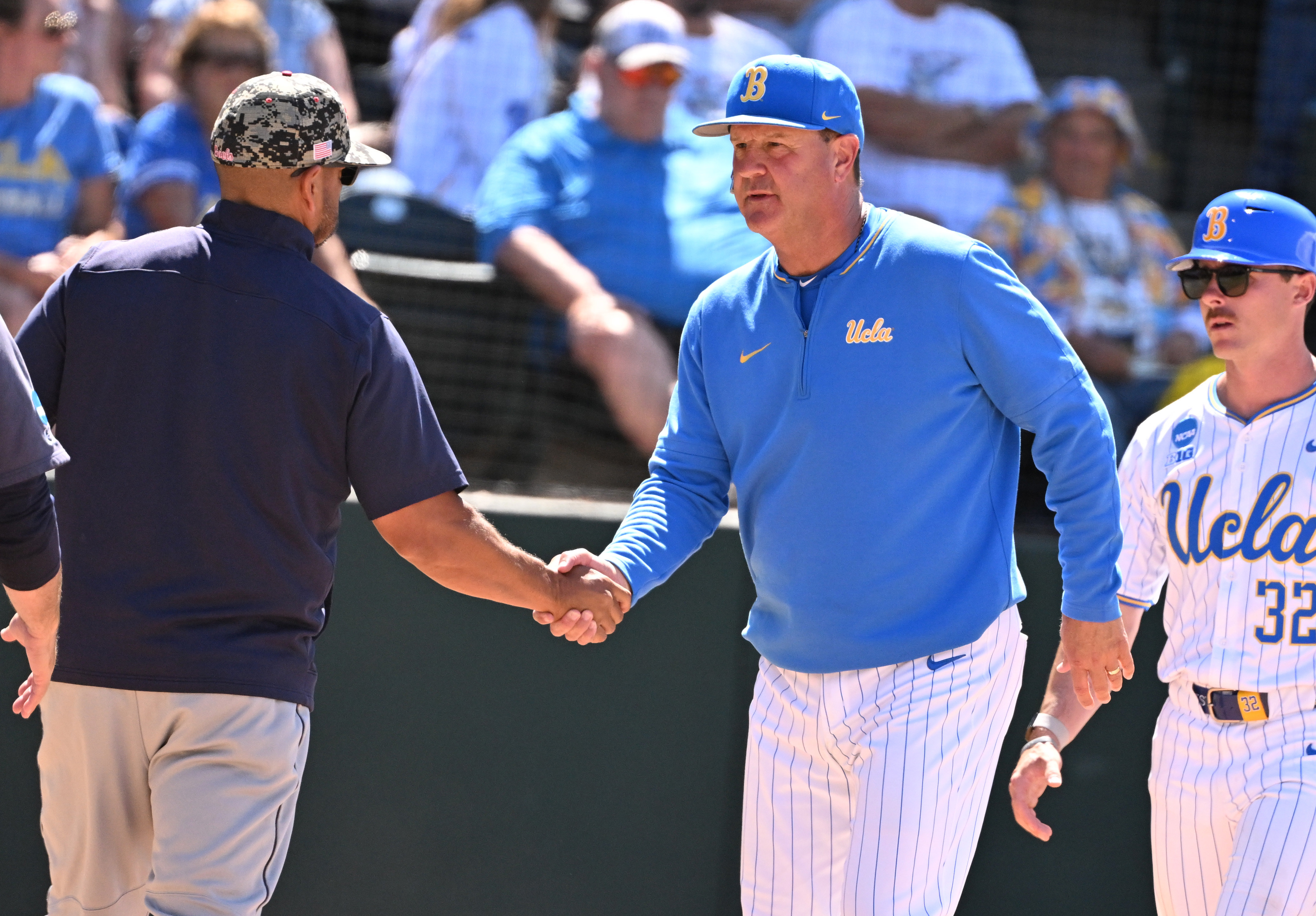 Head coach John Savage of the UCLA Bruins shakes hands...