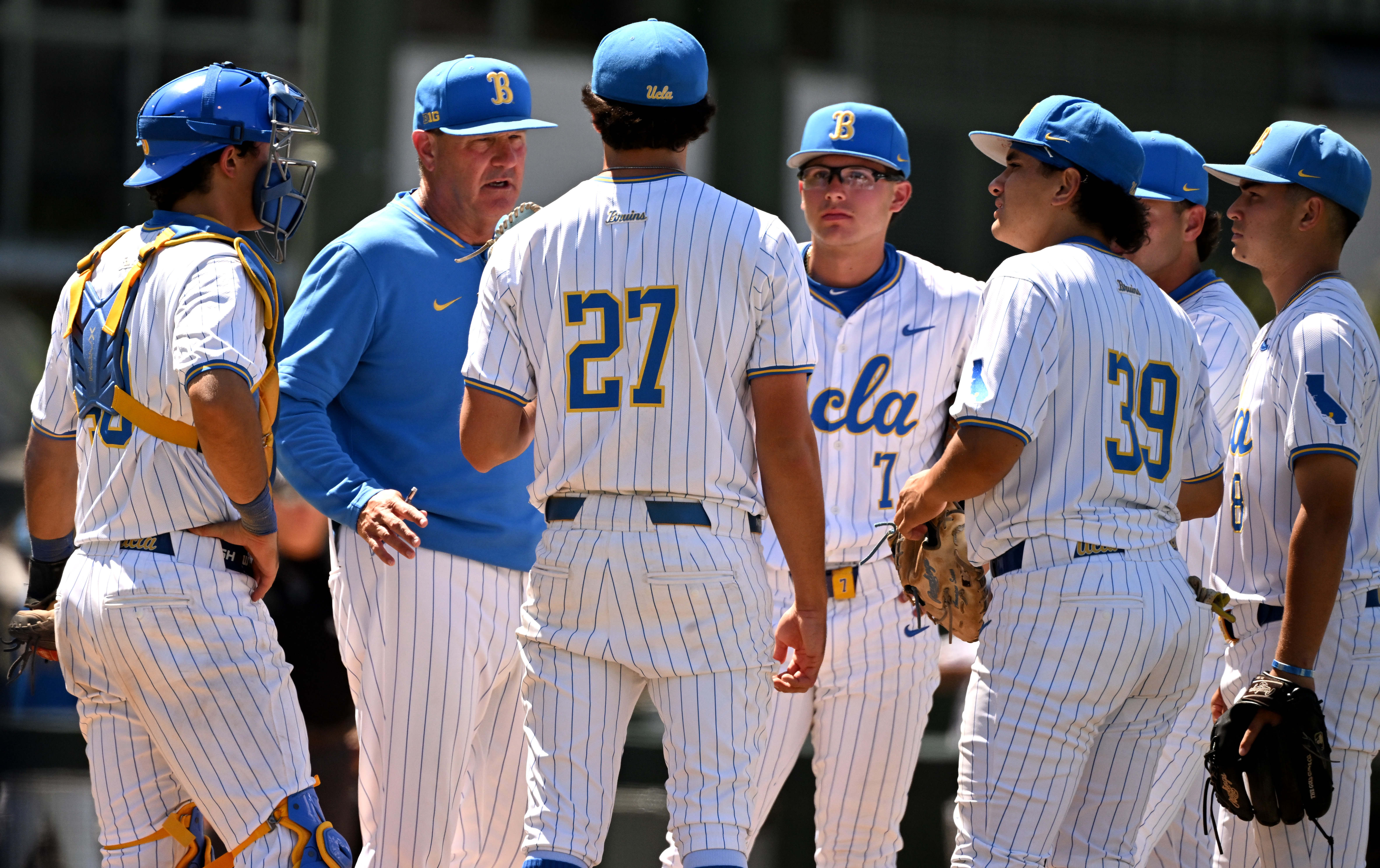 Head coach John Savage speaks with relief pitcher Easton Hawk...
