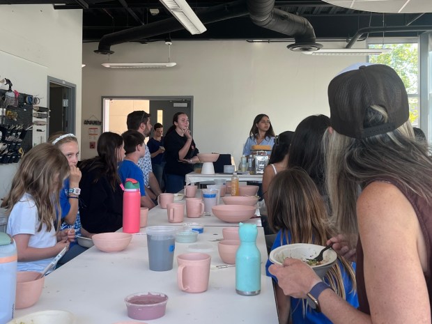 La Jolla Country Day School students Talia Mackin (in the back at left) and Ariela Garma-Nieto (right) led a grant-funded project to provide decorated ceramic bowls, plates and cups to formerly homeless people settling into their new homes. (Noah Lyons)