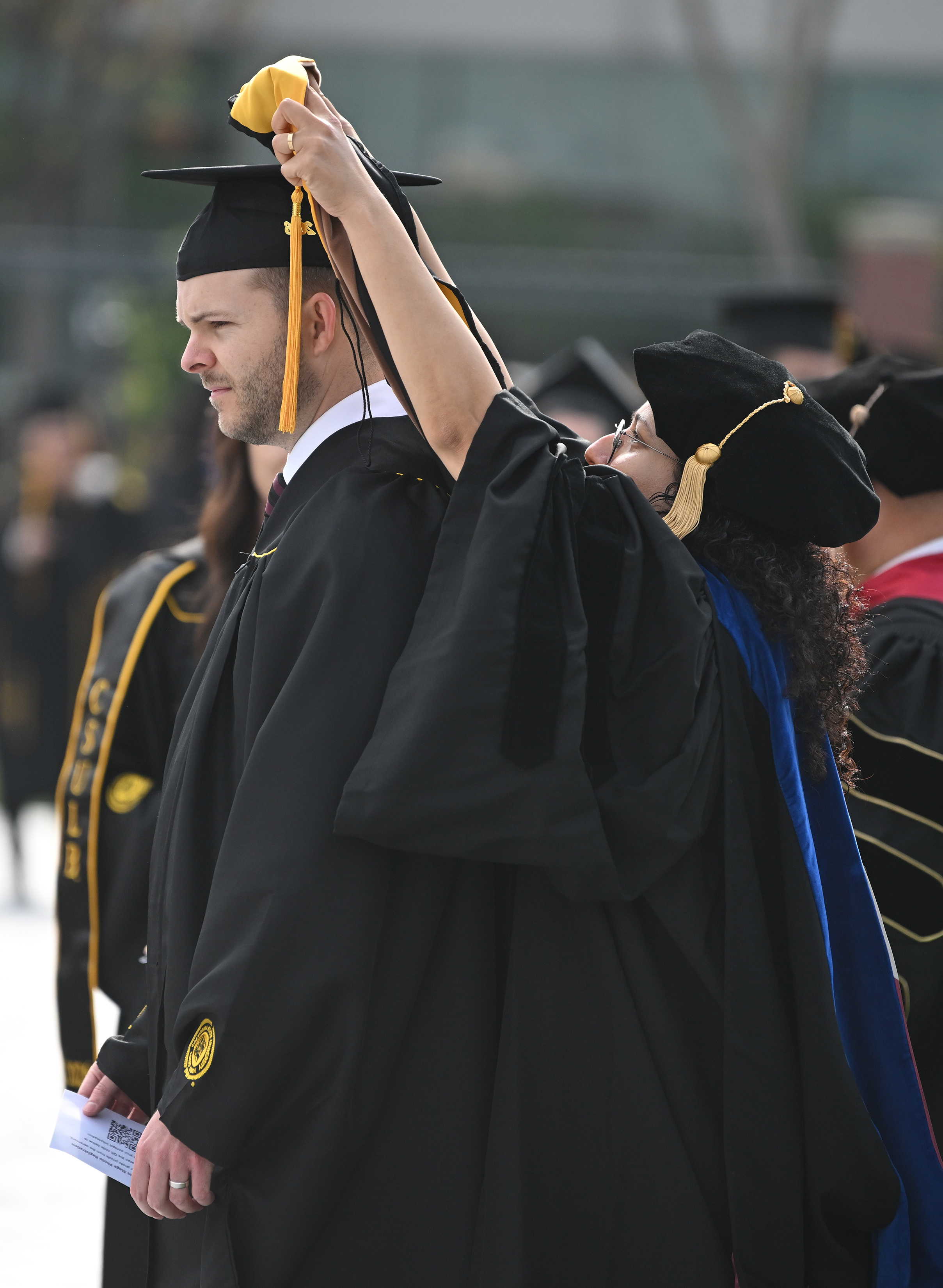 Dr. Mona Zanhour places an academic hood over the head...