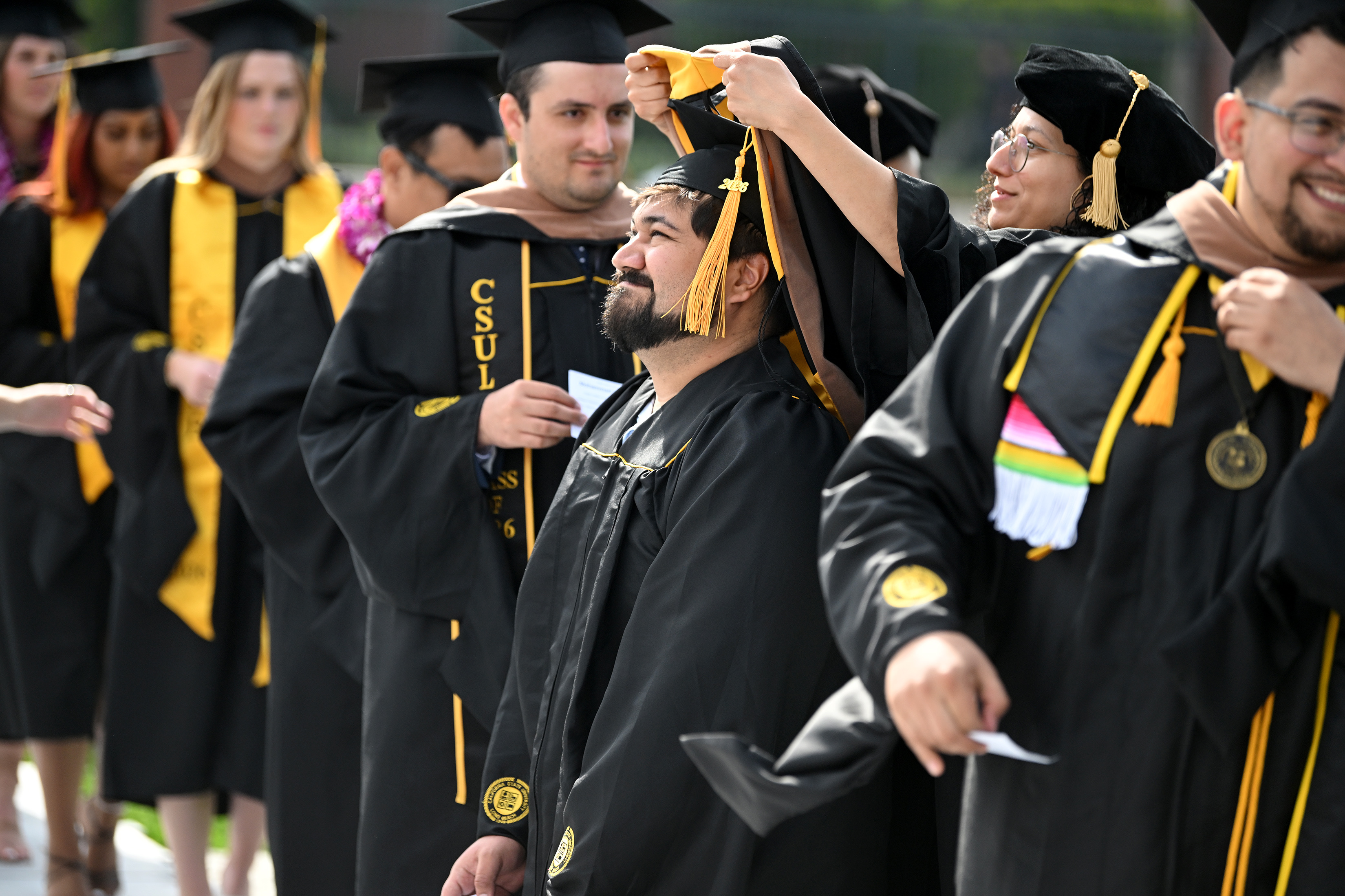 Dr. Mona Zanhour places an academic hood over the head...