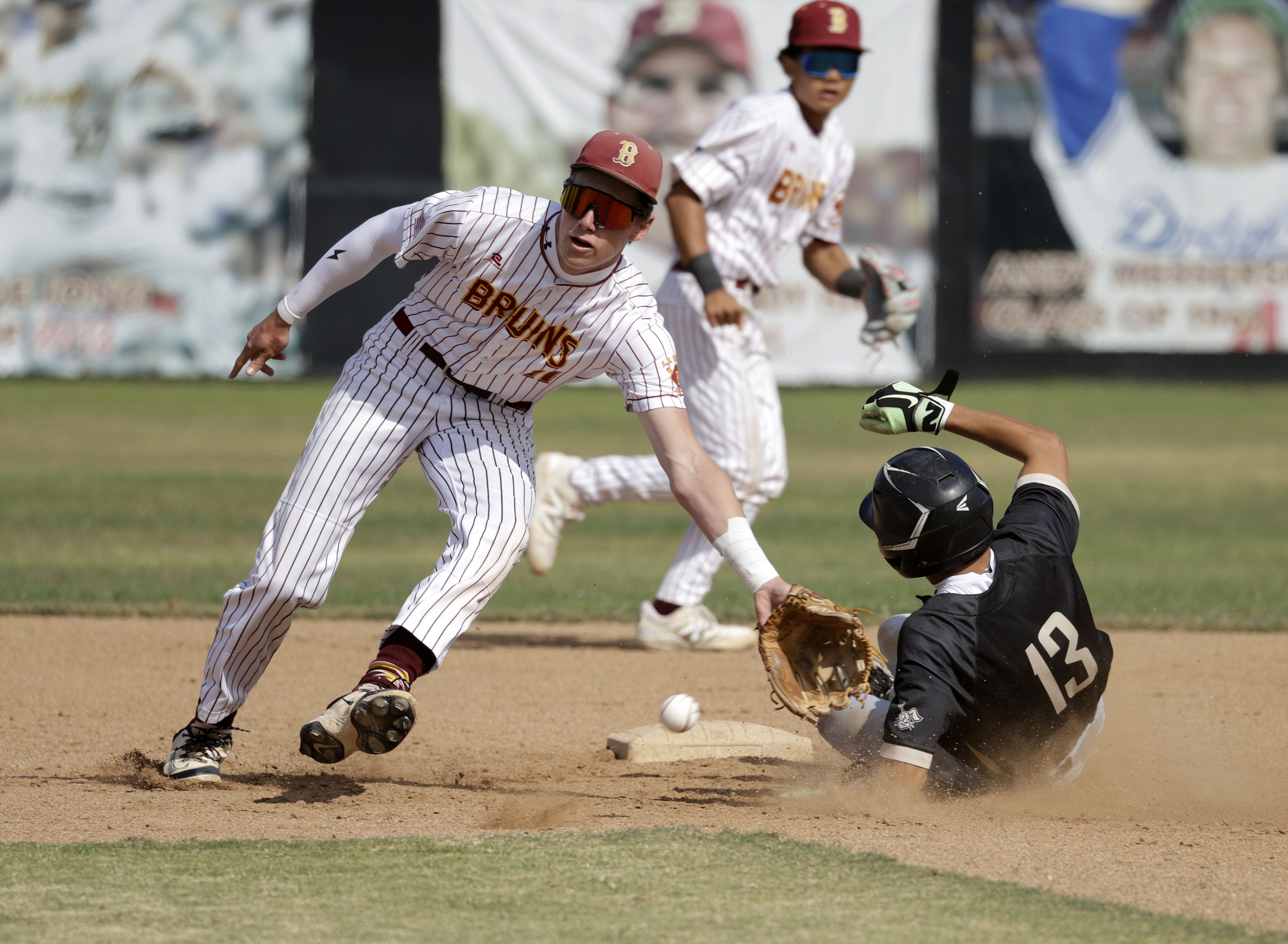 Long Beach Poly’s Fausto Gaxiola III (13) slides safely into...