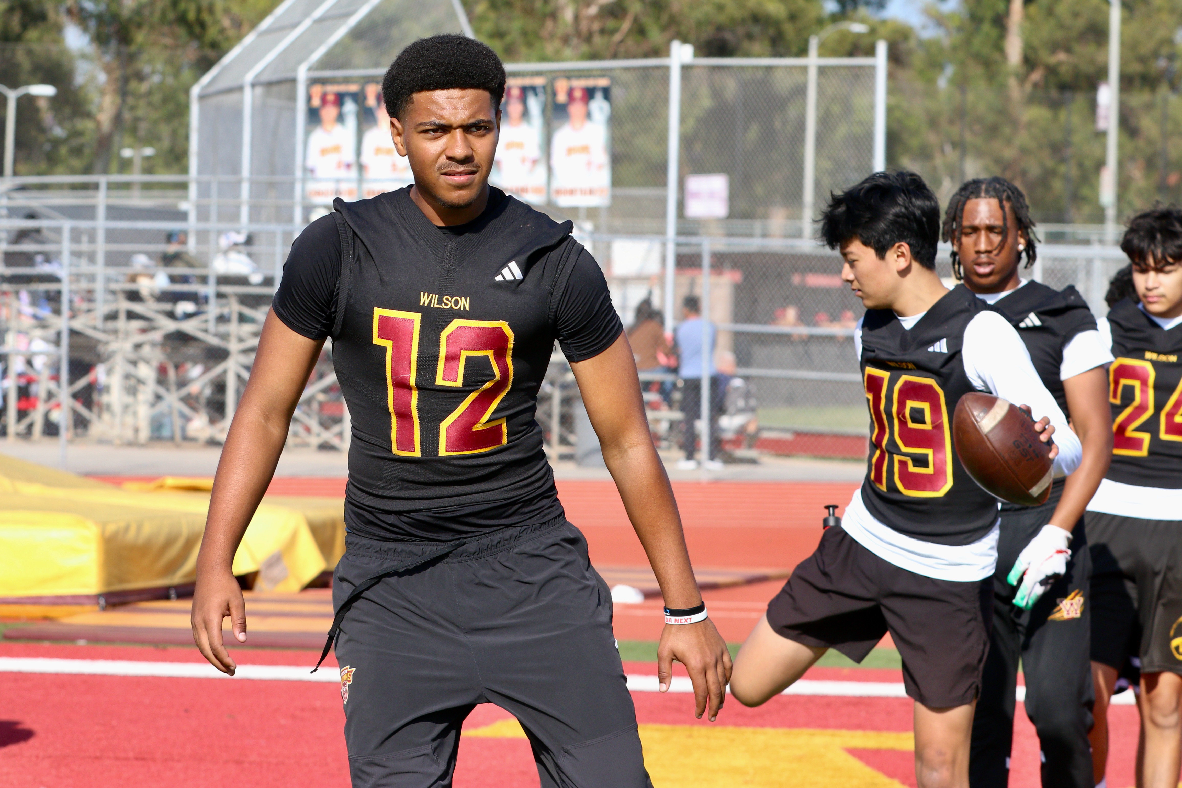 Wilson quarterback loosens up with teammates during a spring football...