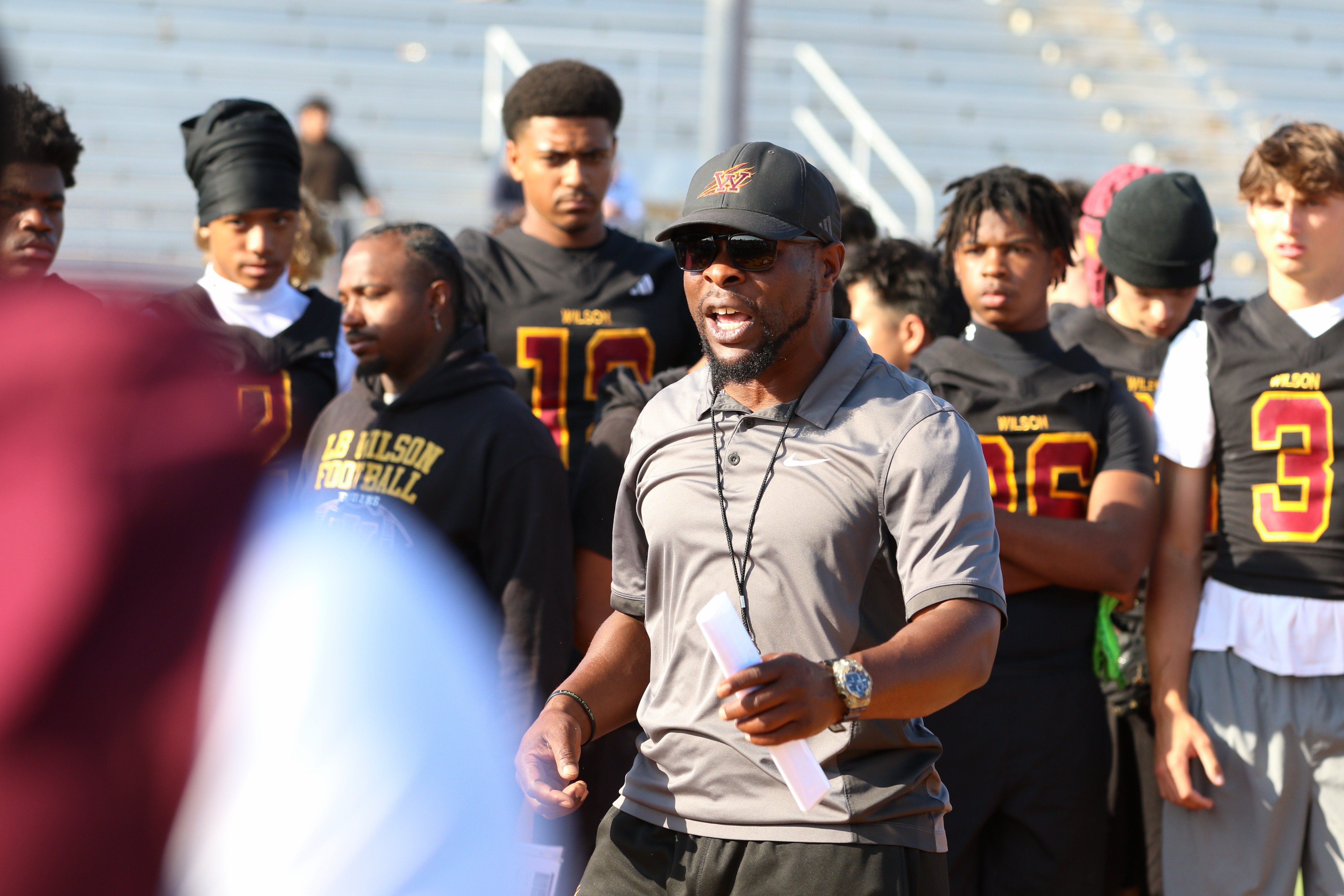 Wilson assistant coach Larmar Avila addresses players during a spring...