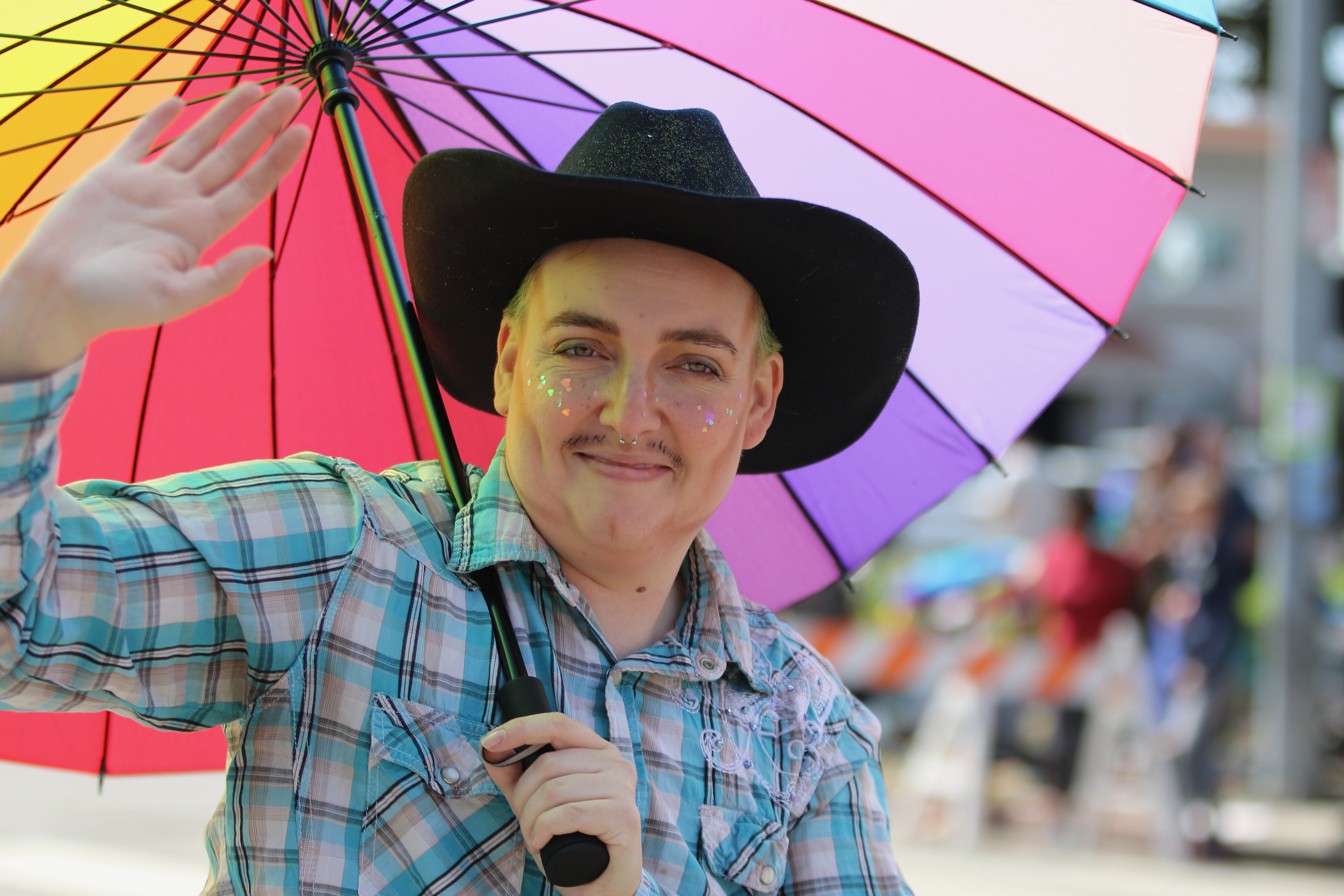 A participant waves to spectators at the Long Beach Pride...