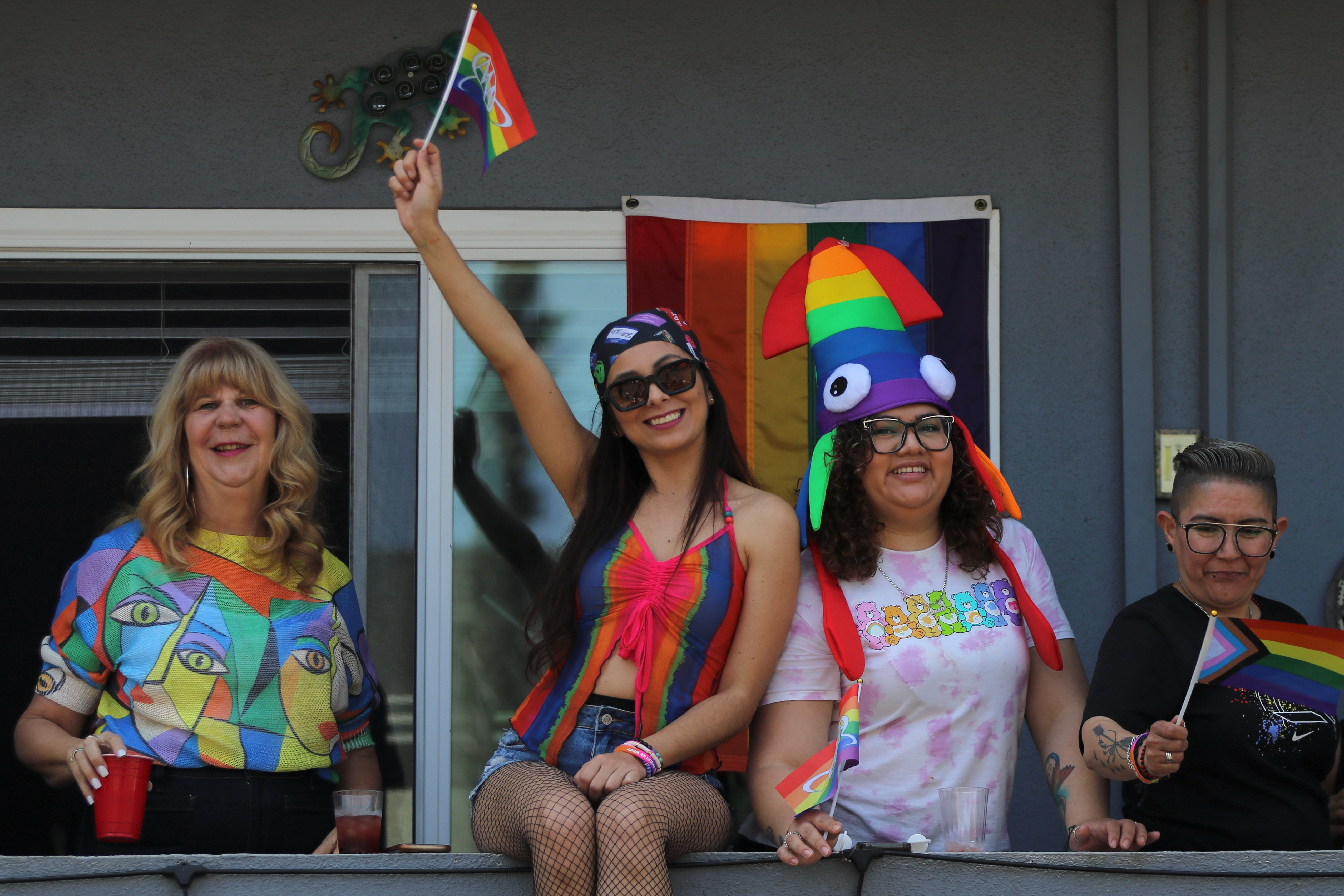 Spectators view the Long Beach Pride Parade from a balcony...