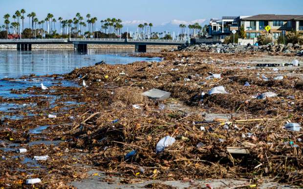 Trash and debris is piled up along the bank of the San Gabriel River just a few hundred yards from the Pacific Ocean in Seal Beach in 2022. Heavy rains send trash flowing down the river from many miles inland, a problem that has plagued the beach town for decades. (Photo by Mark Rightmire, Orange County Register/SCNG)