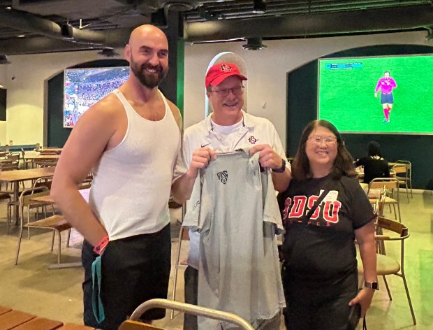 San Diego State fans Greg and Irene Shaffer with football coach Sean Lewis. (Kirk Kenney / San Diego Union-Tribune)