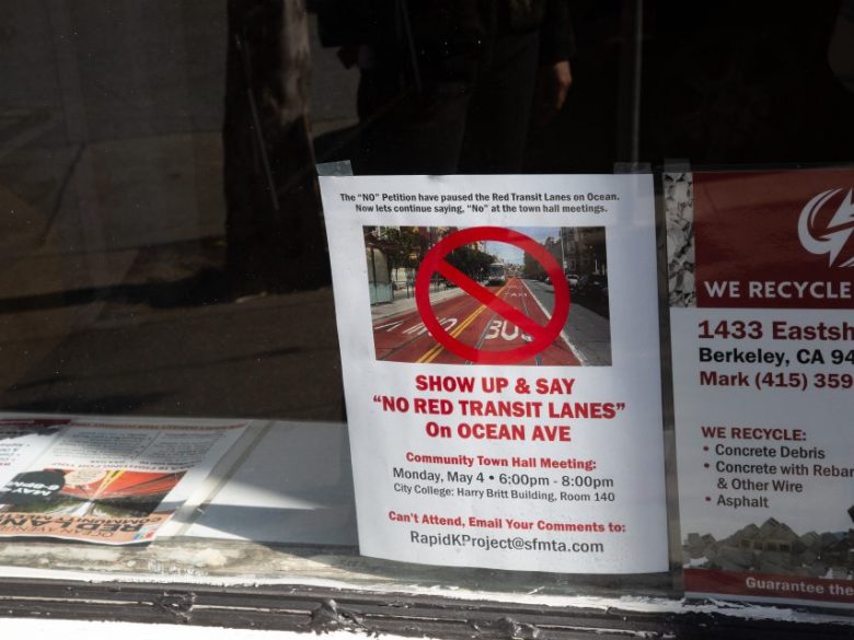 Flyer on window with a red crossed circle over a photo of a bus lane, advertising a community meeting opposing red transit lanes on Ocean Ave in Berkeley, CA.