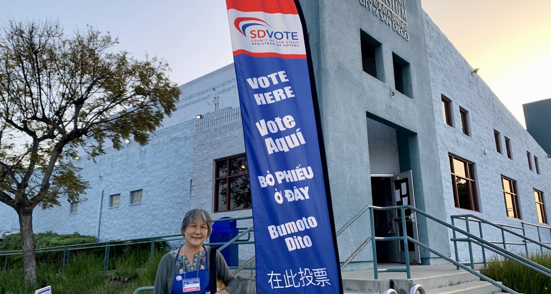 A Poll worker standing in front of a vote center.