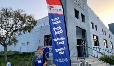 A Poll worker standing in front of a vote center.
