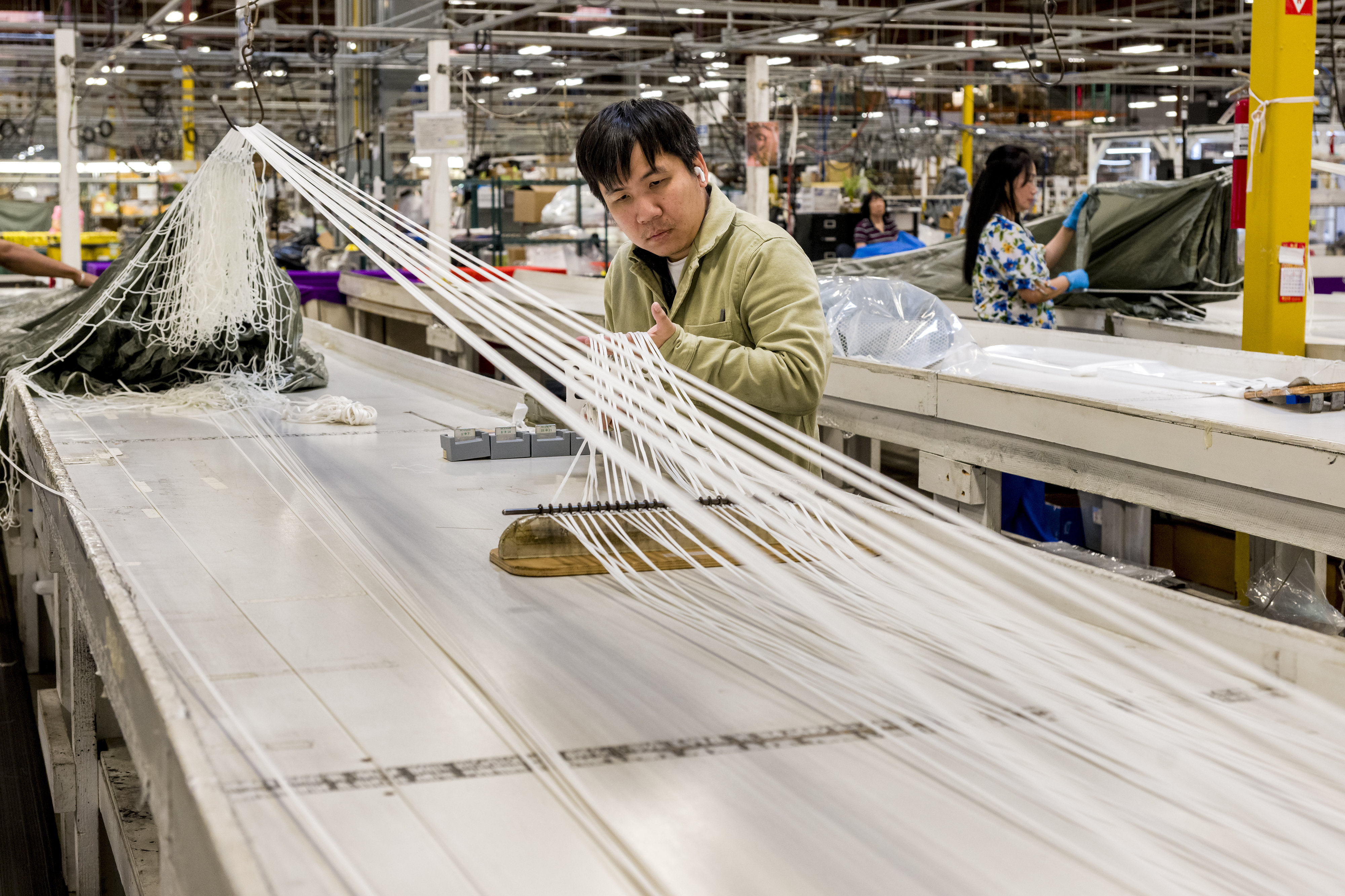 Minh Duong lays out parachute suspension lines at Airborne Systems...