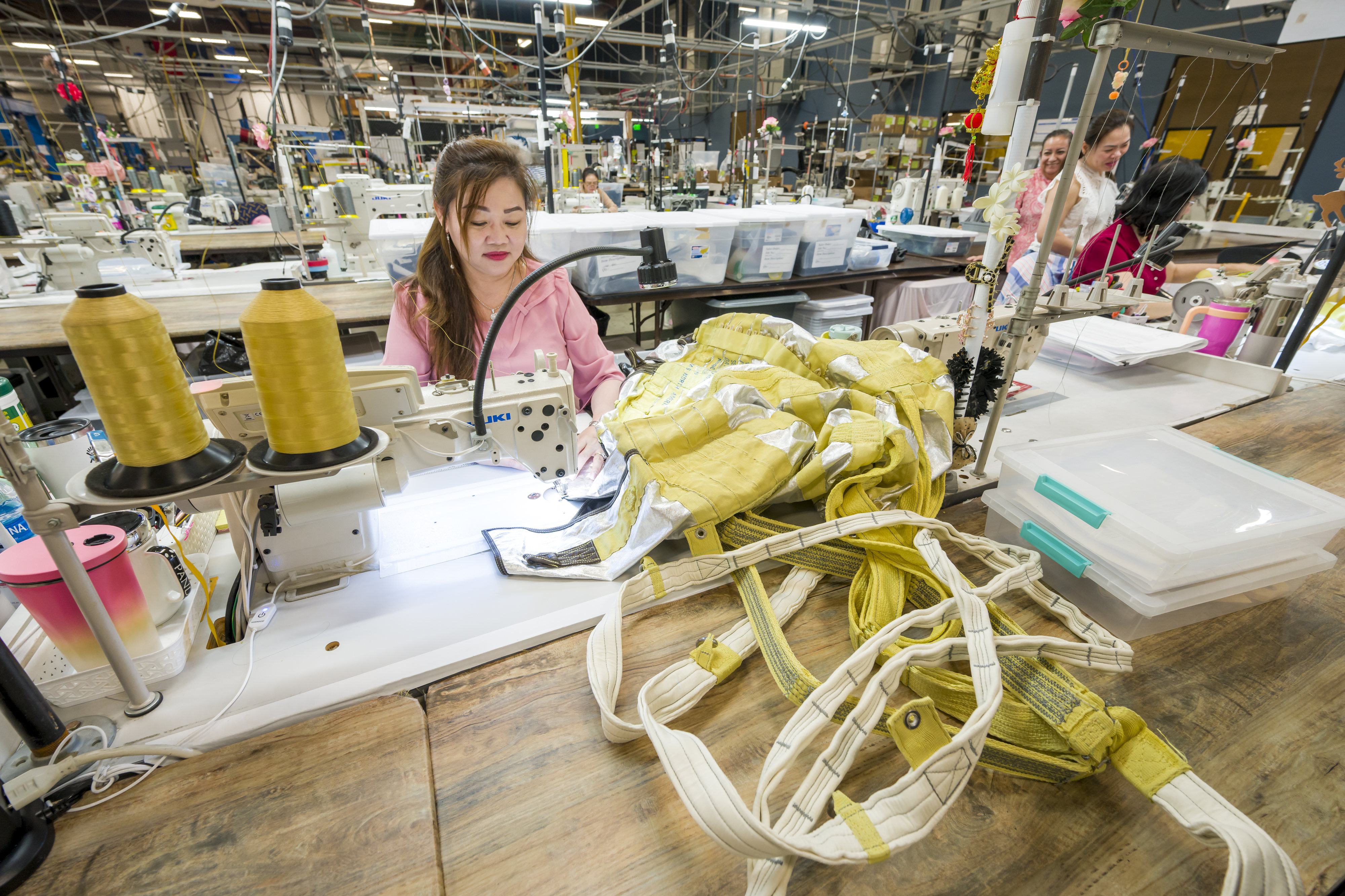 Lan Ngo sews a parachute deployment bag at Airborne Systems...