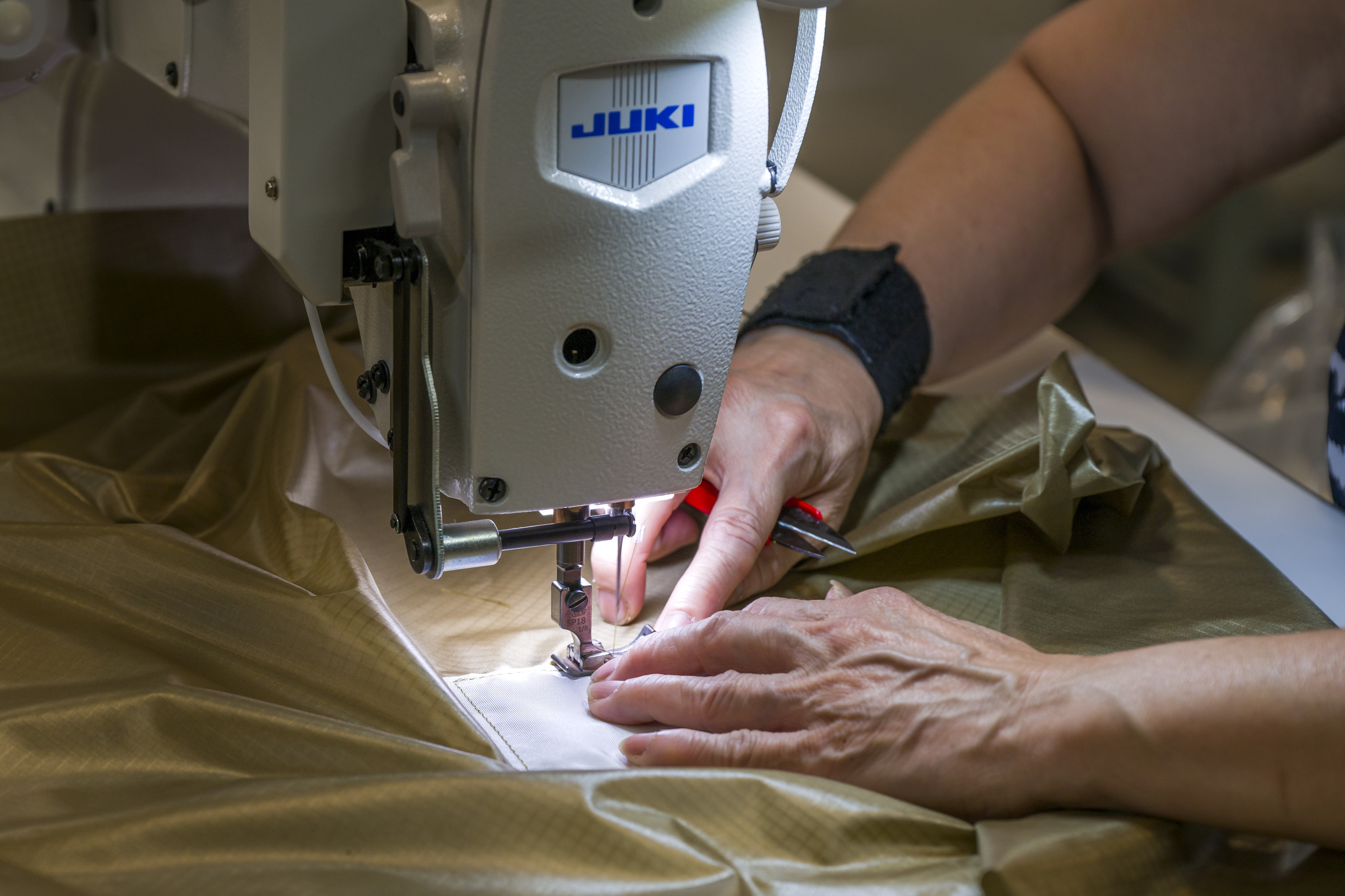 Hang Vuong, a sewing machine operator, works on a Juki...