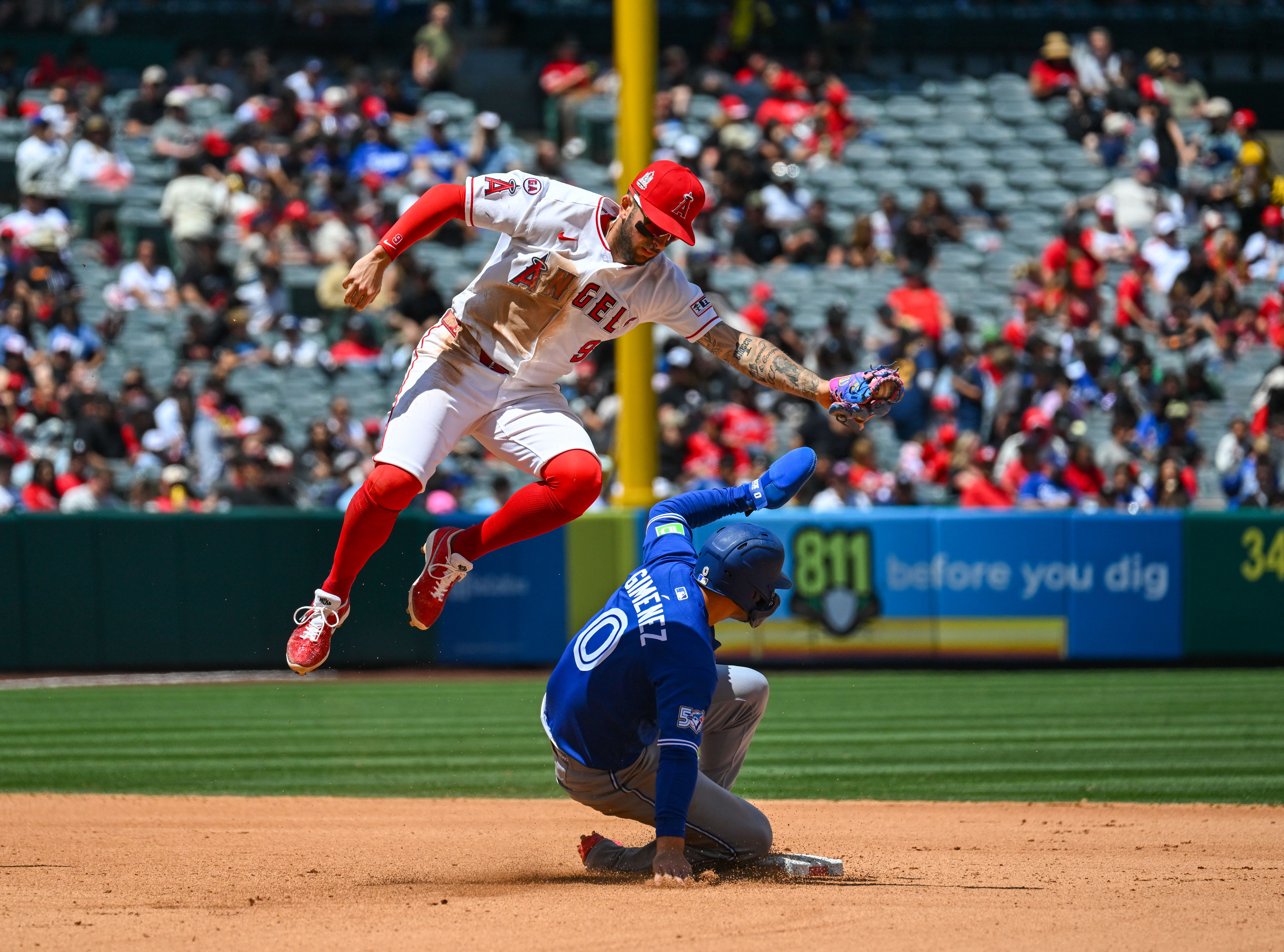 The Blue Jays Andres Gimenez (0) slides under the Angels...