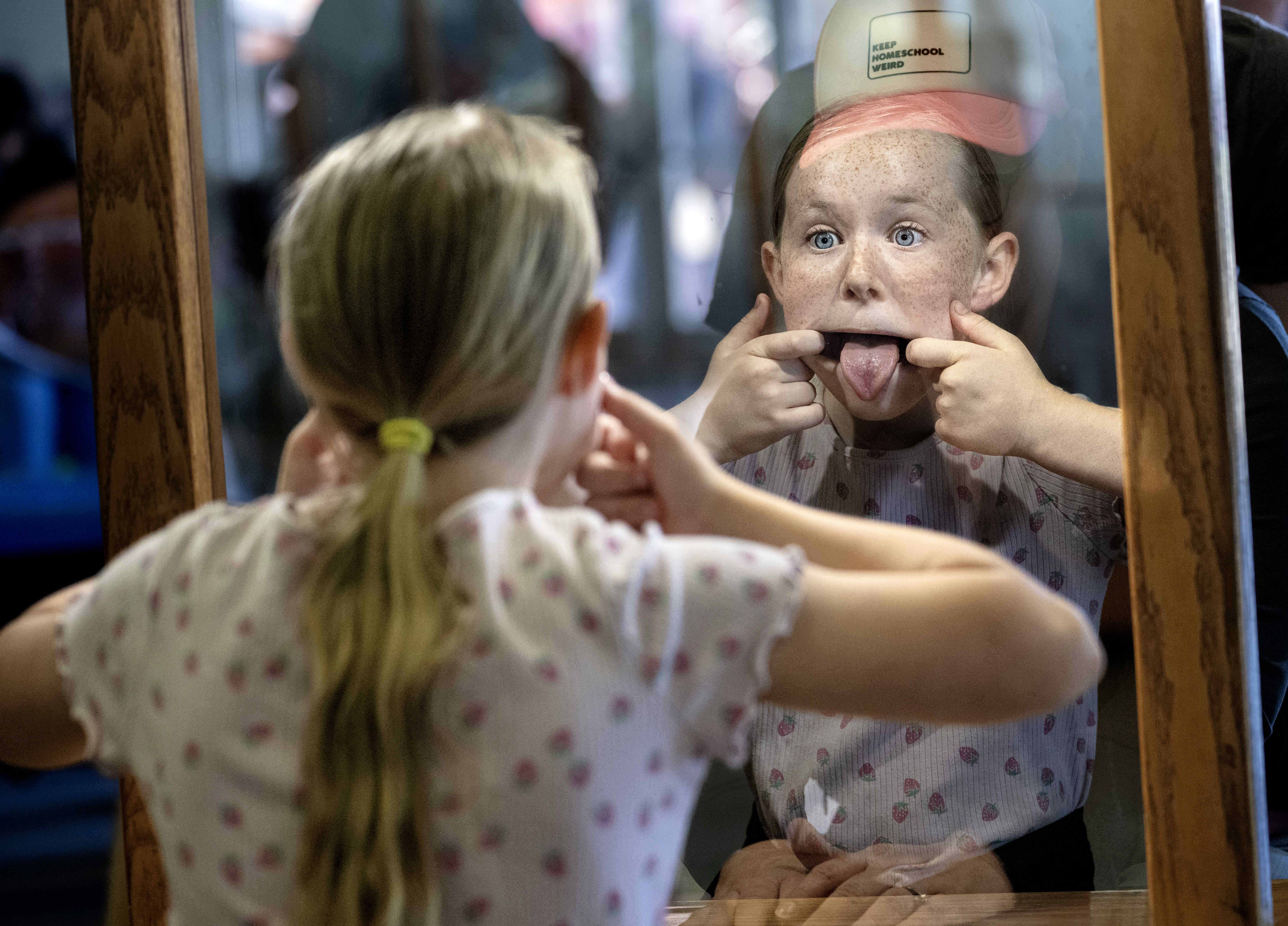 Nine-year-old Sierra Swaney tests out the “morphing mirror,” as she...