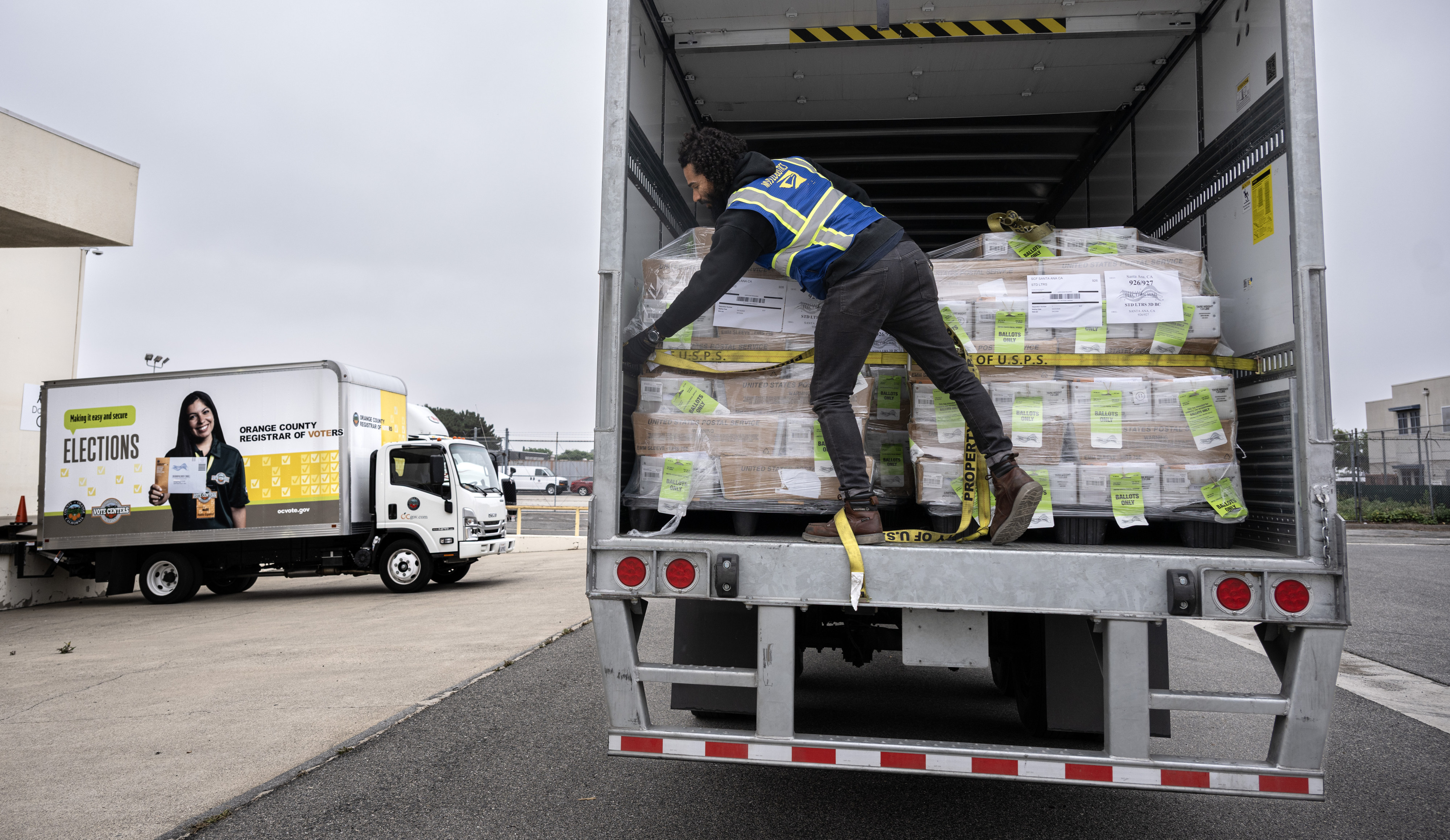 USPS employee Taylor Jeffers loads voter ballots onto a 53-foot-long...
