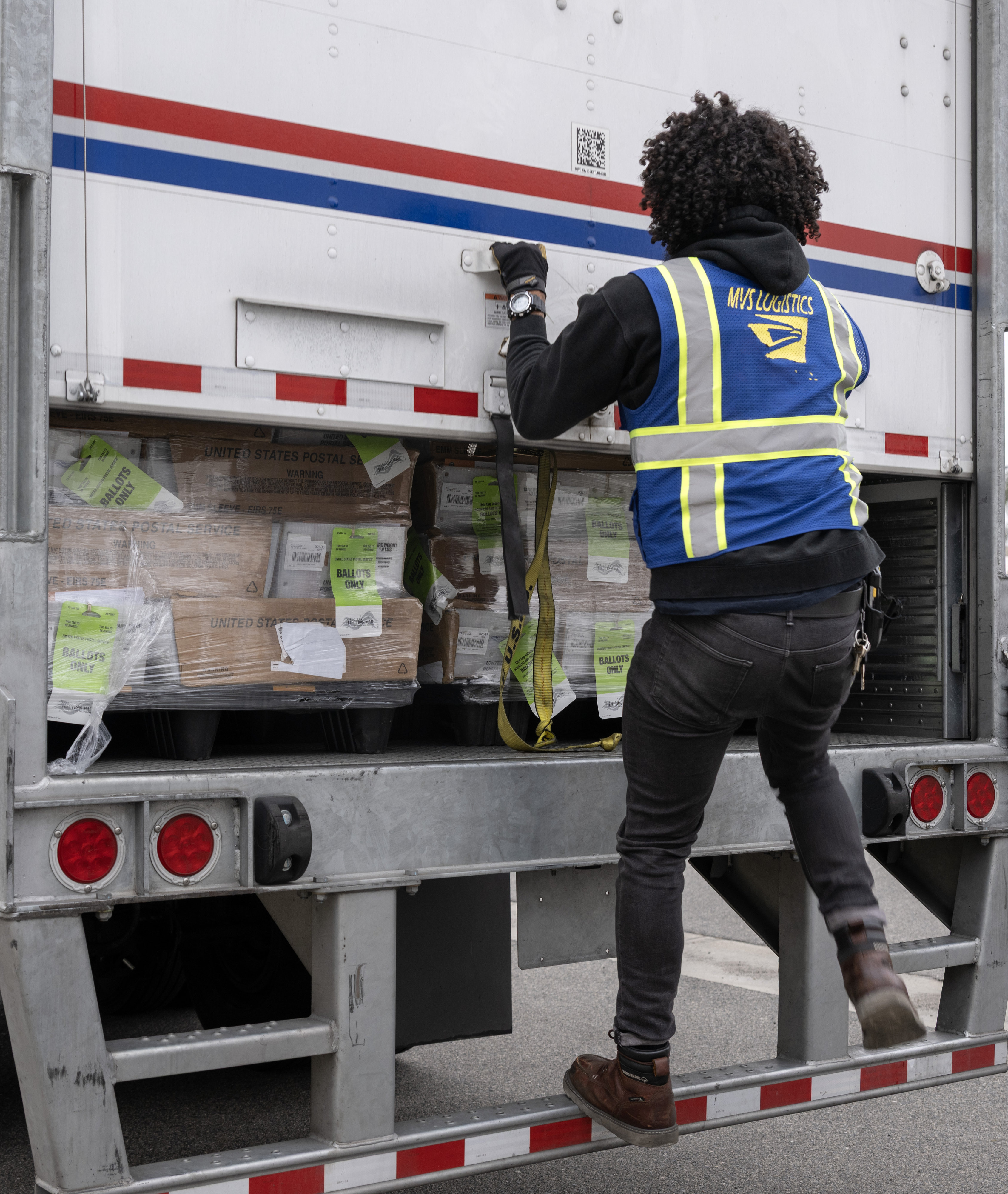 USPS employee Taylor Jeffers gets ready to deliver a truckload...
