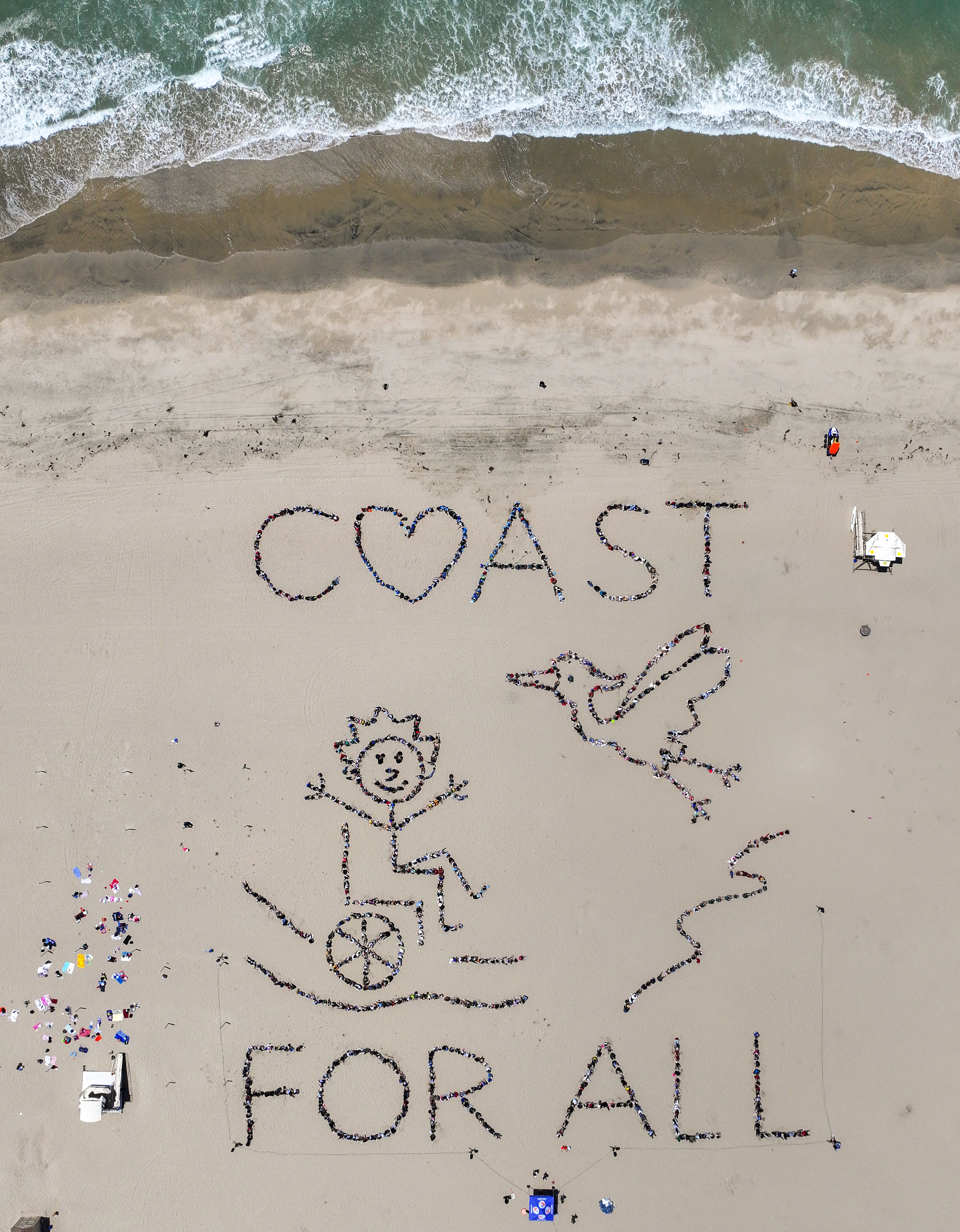 Over 1,000 kids form a giant artwork in the sand...