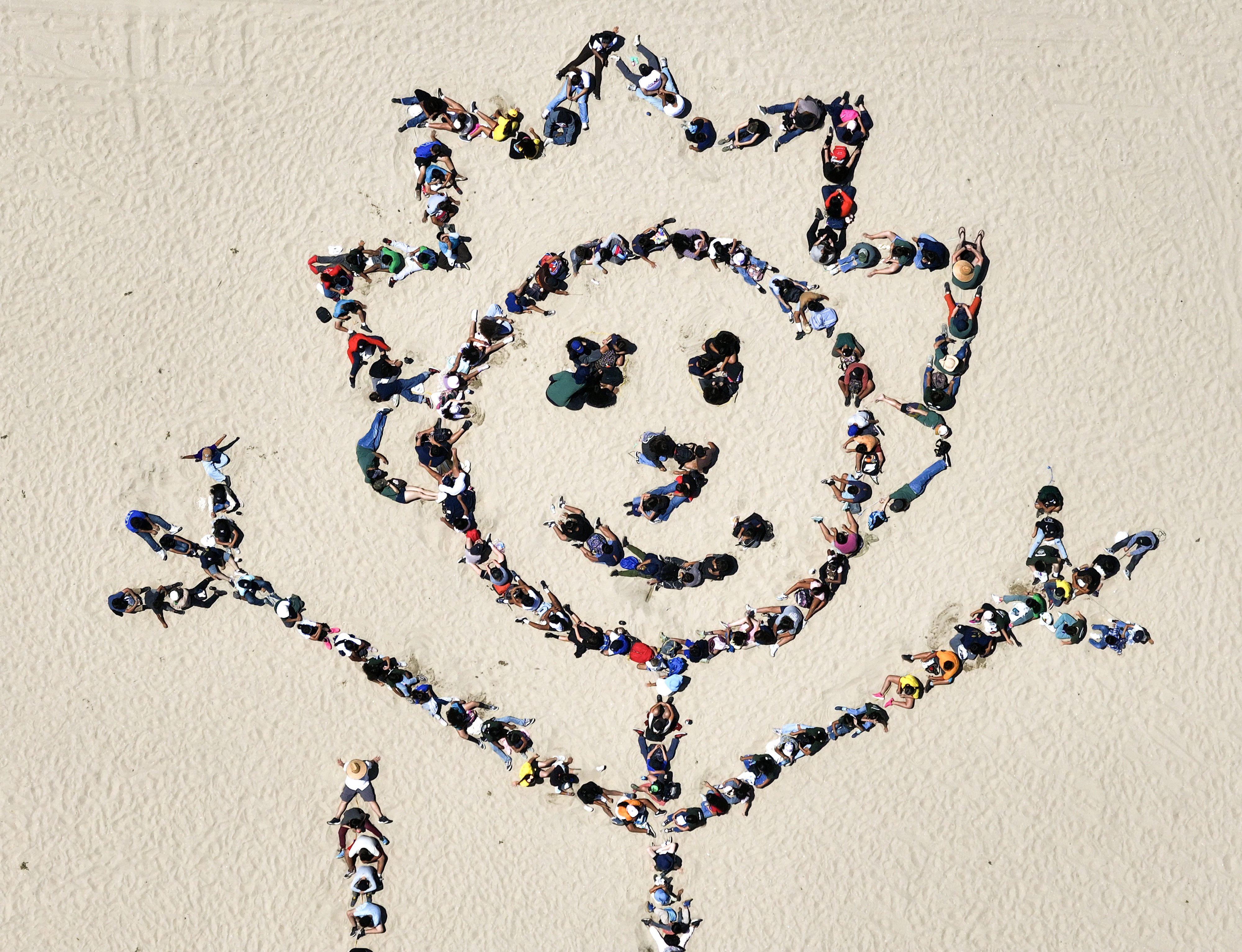 Over 1,000 kids form a giant artwork in the sand...