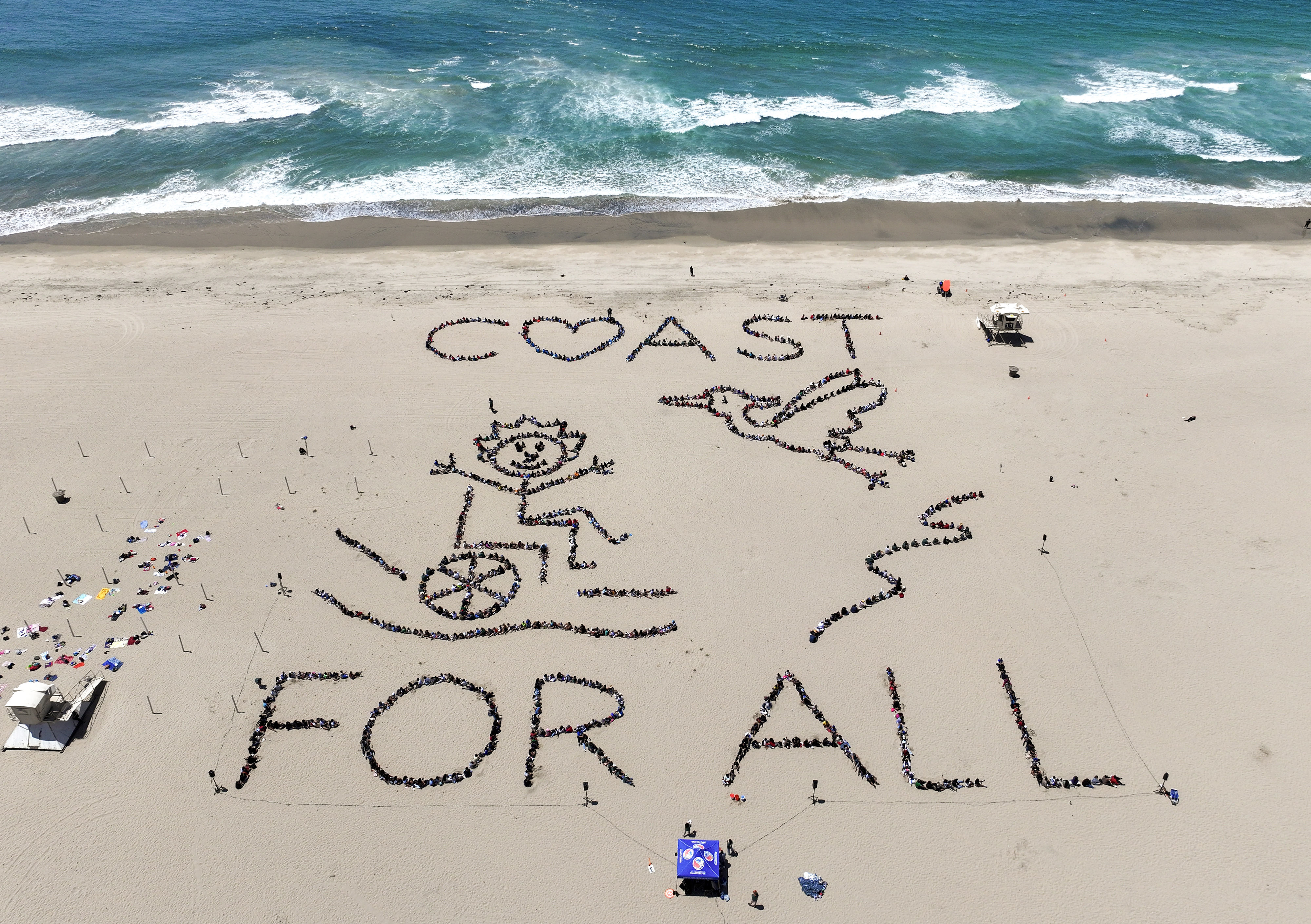 Over 1,000 kids form a giant artwork in the sand...