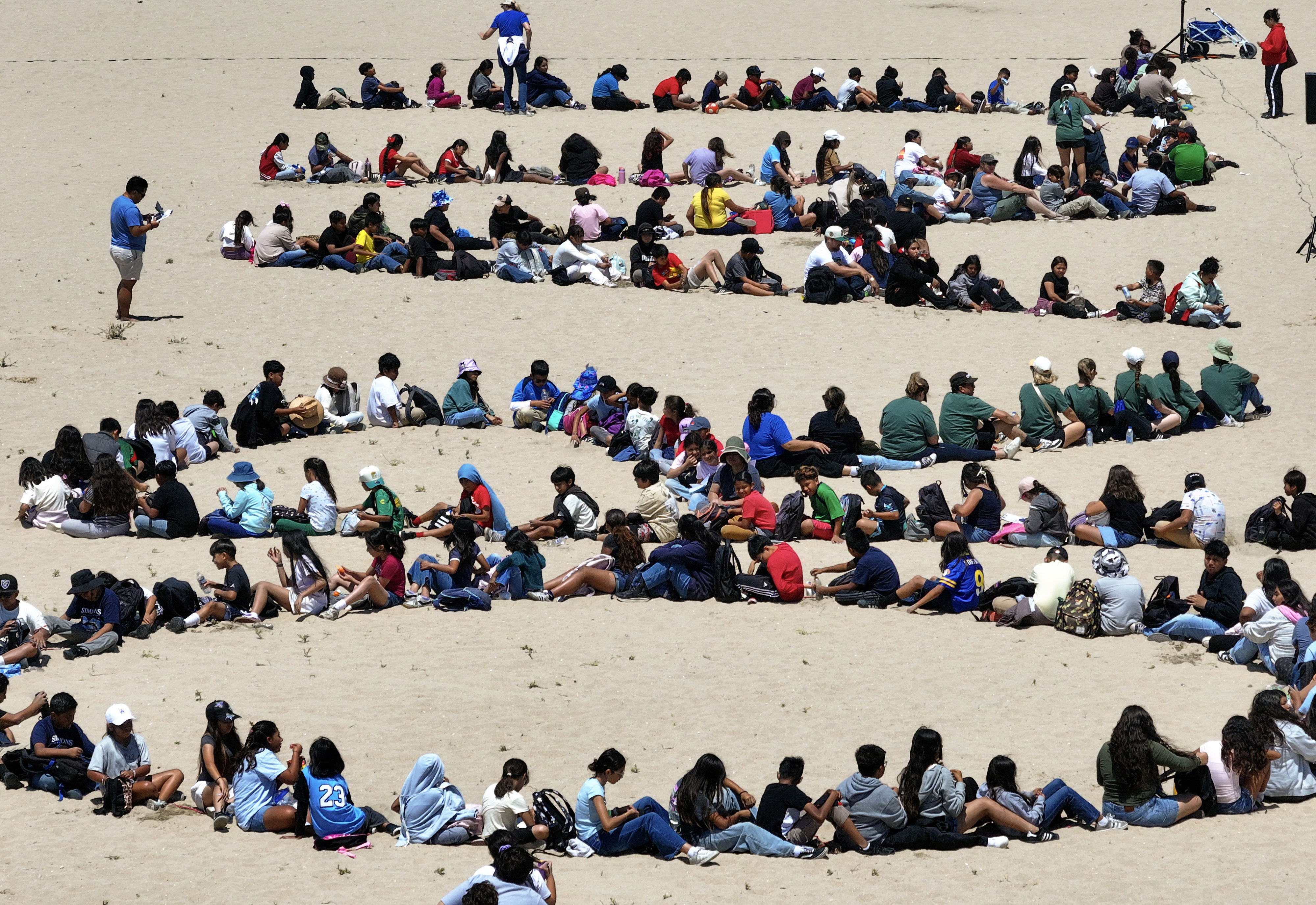 Over 1,000 kids form a giant artwork in the sand...