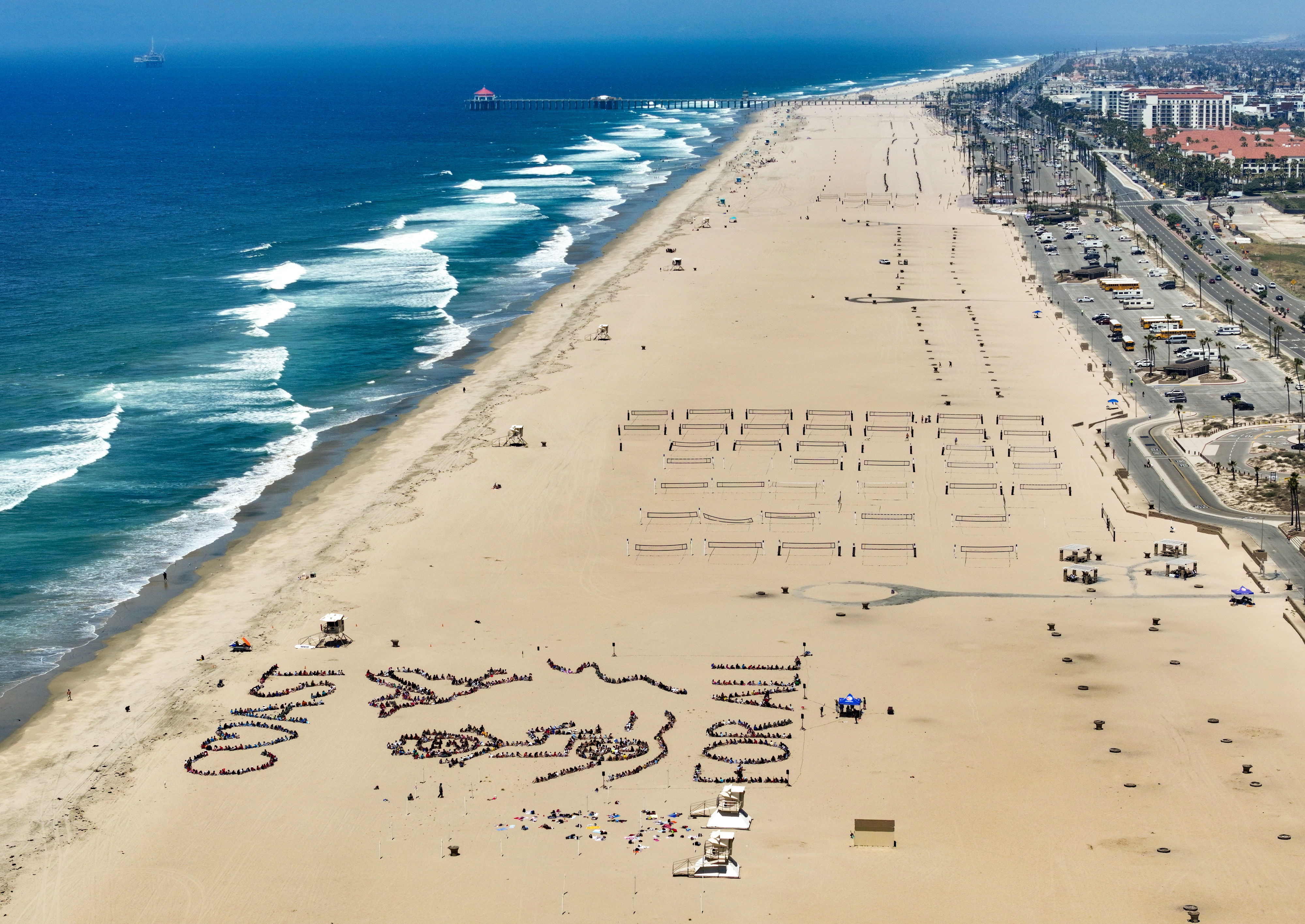 Over 1,000 kids form a giant artwork in the sand...