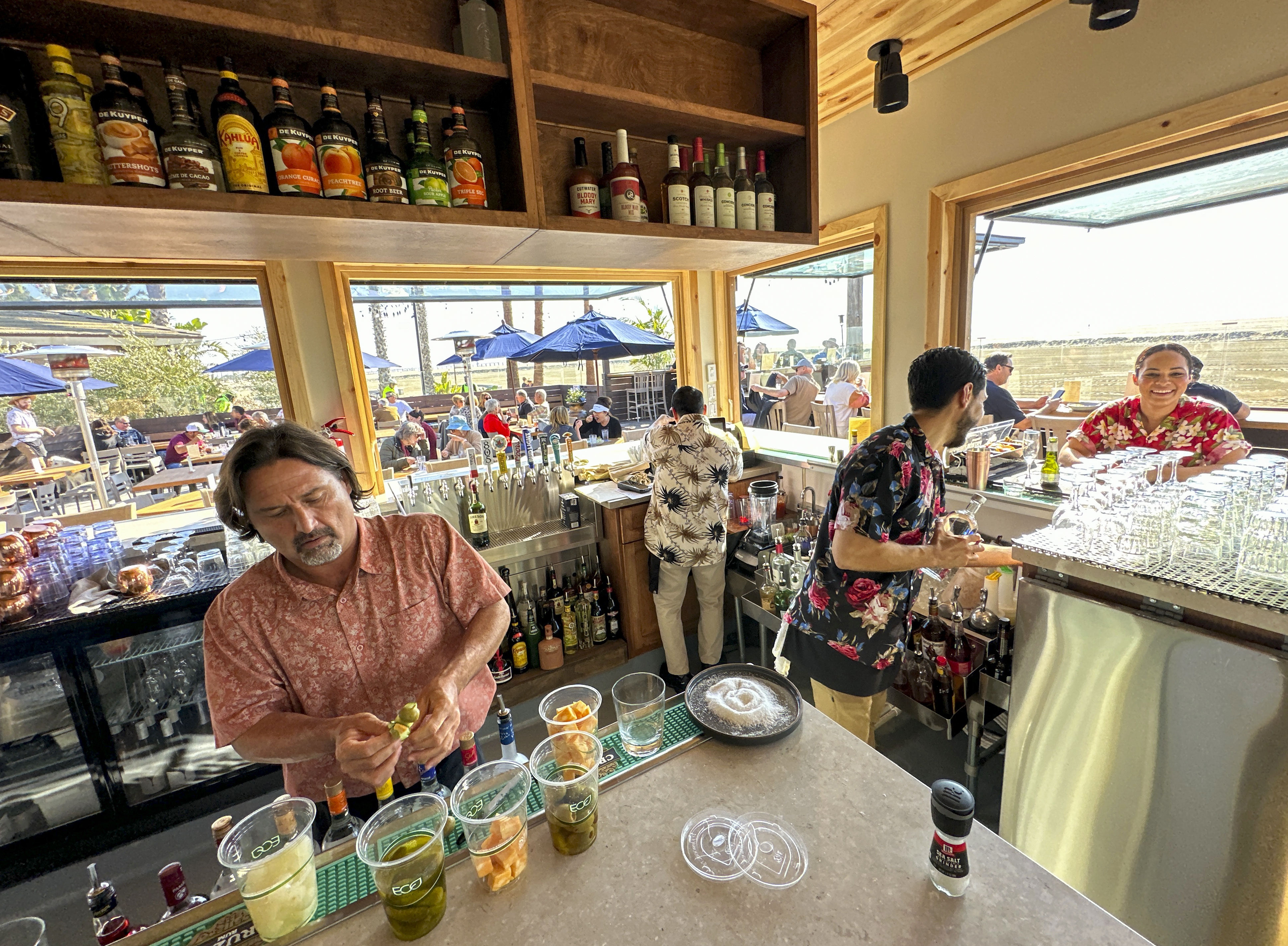 Workers prepare drinks during opening day at The Beach House...