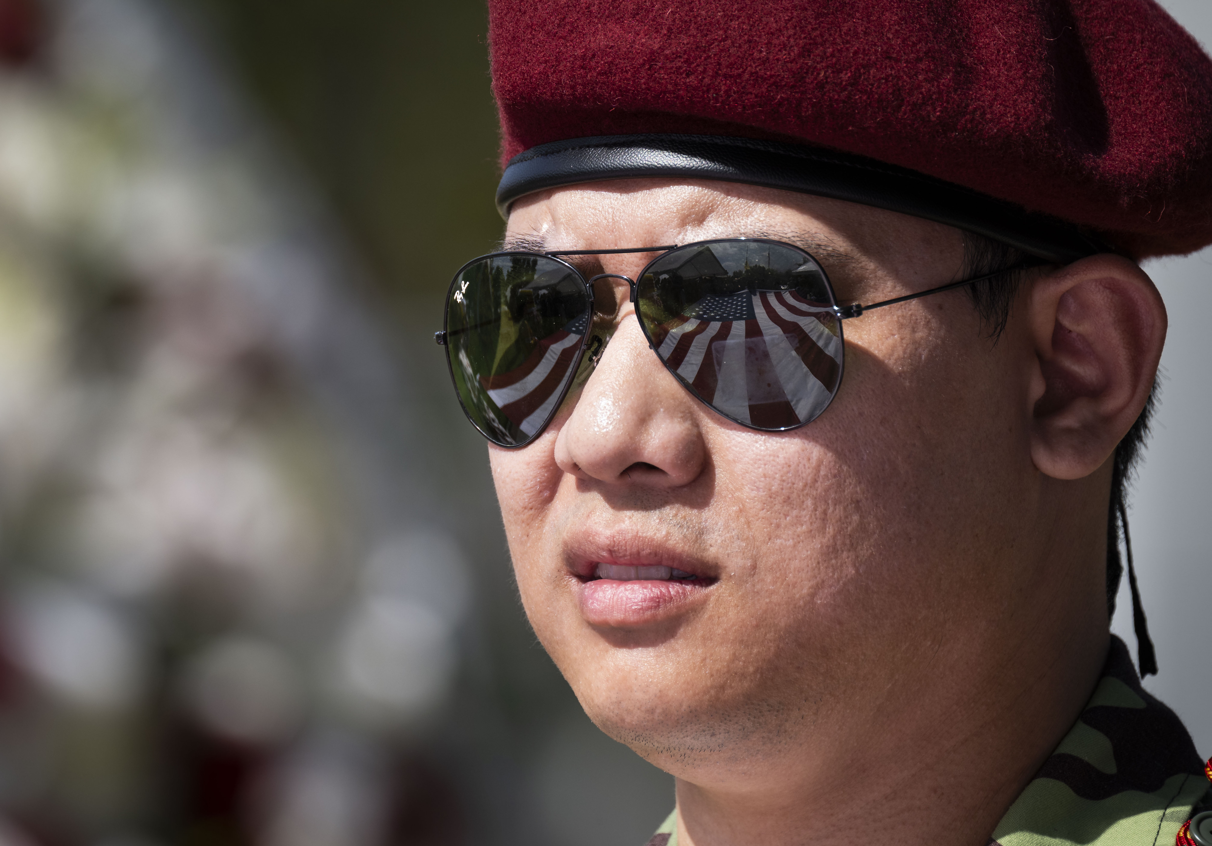 The American flag is reflected in a manâs sunglasses during...
