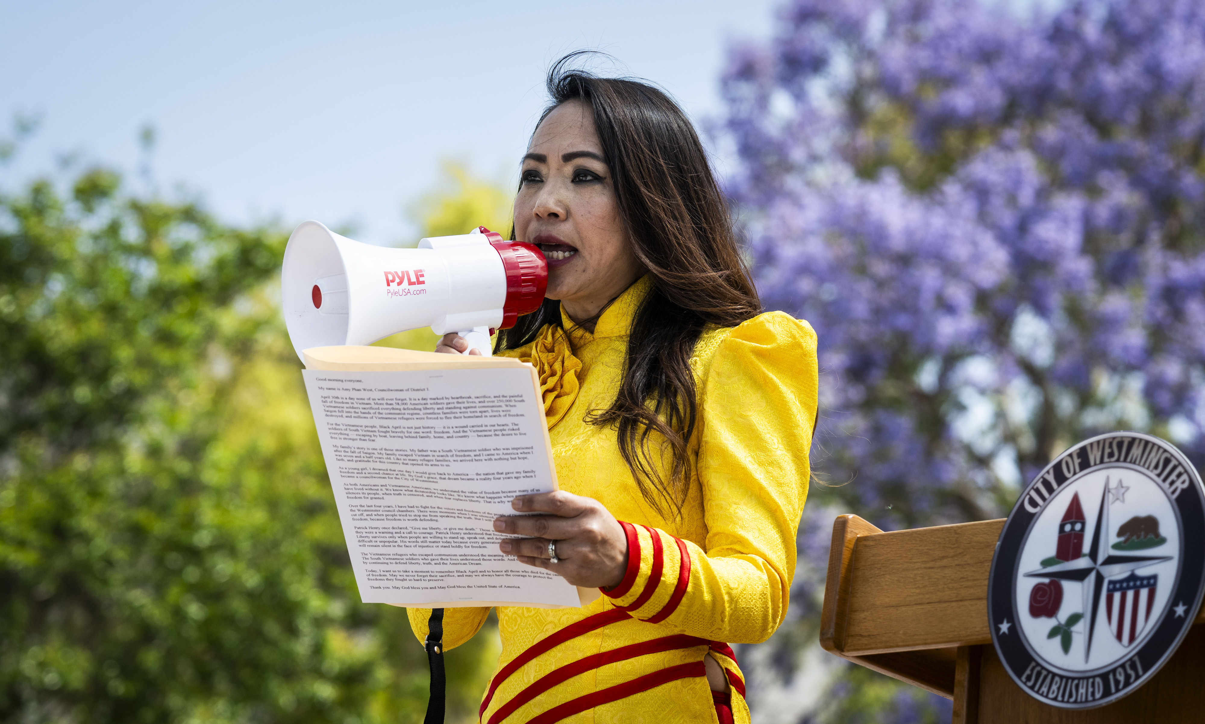 Westminster councilwoman Amy Phan West uses a bullhorn to speak...