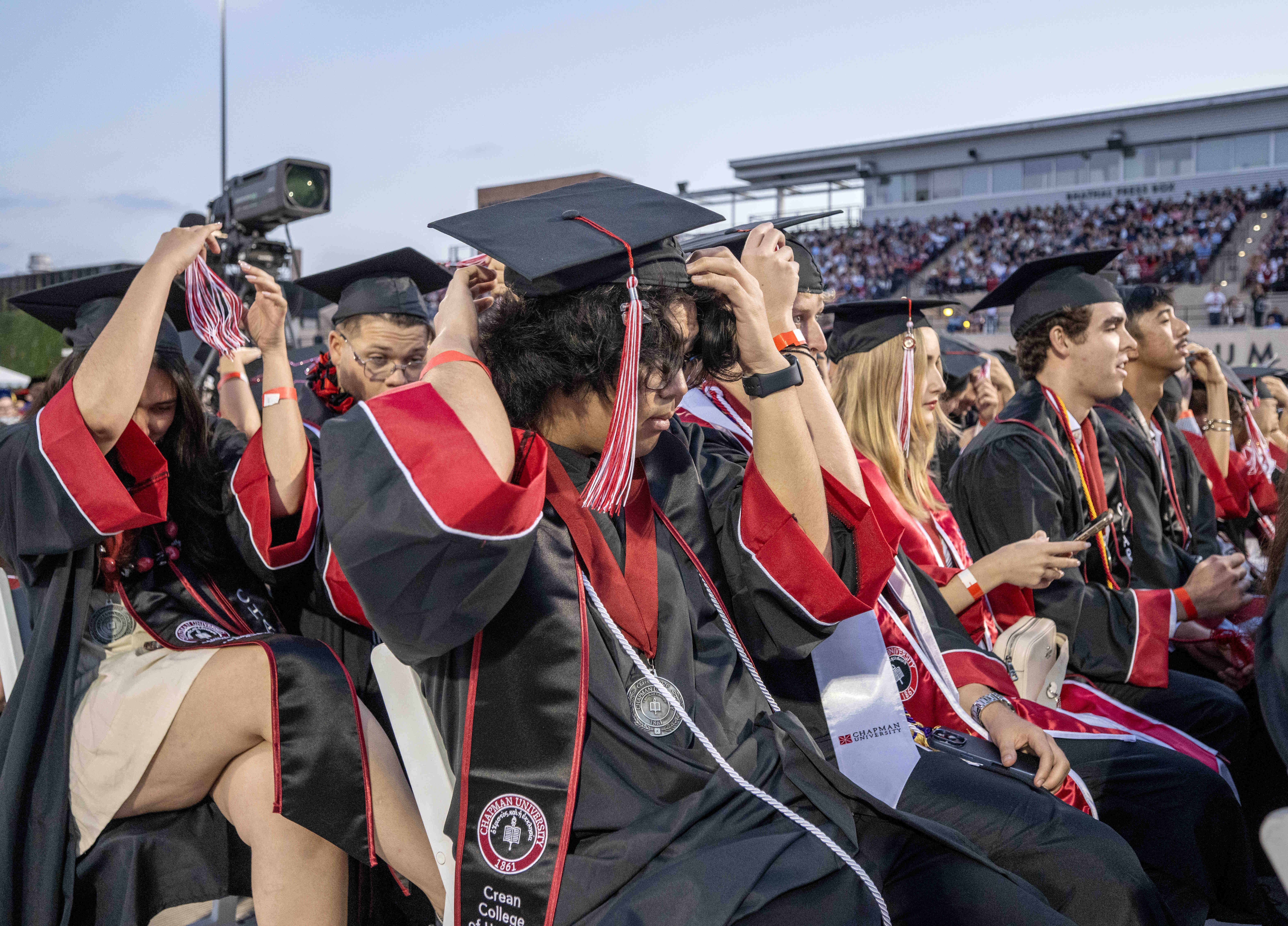 Graduates turn their tassels from right to left as they...