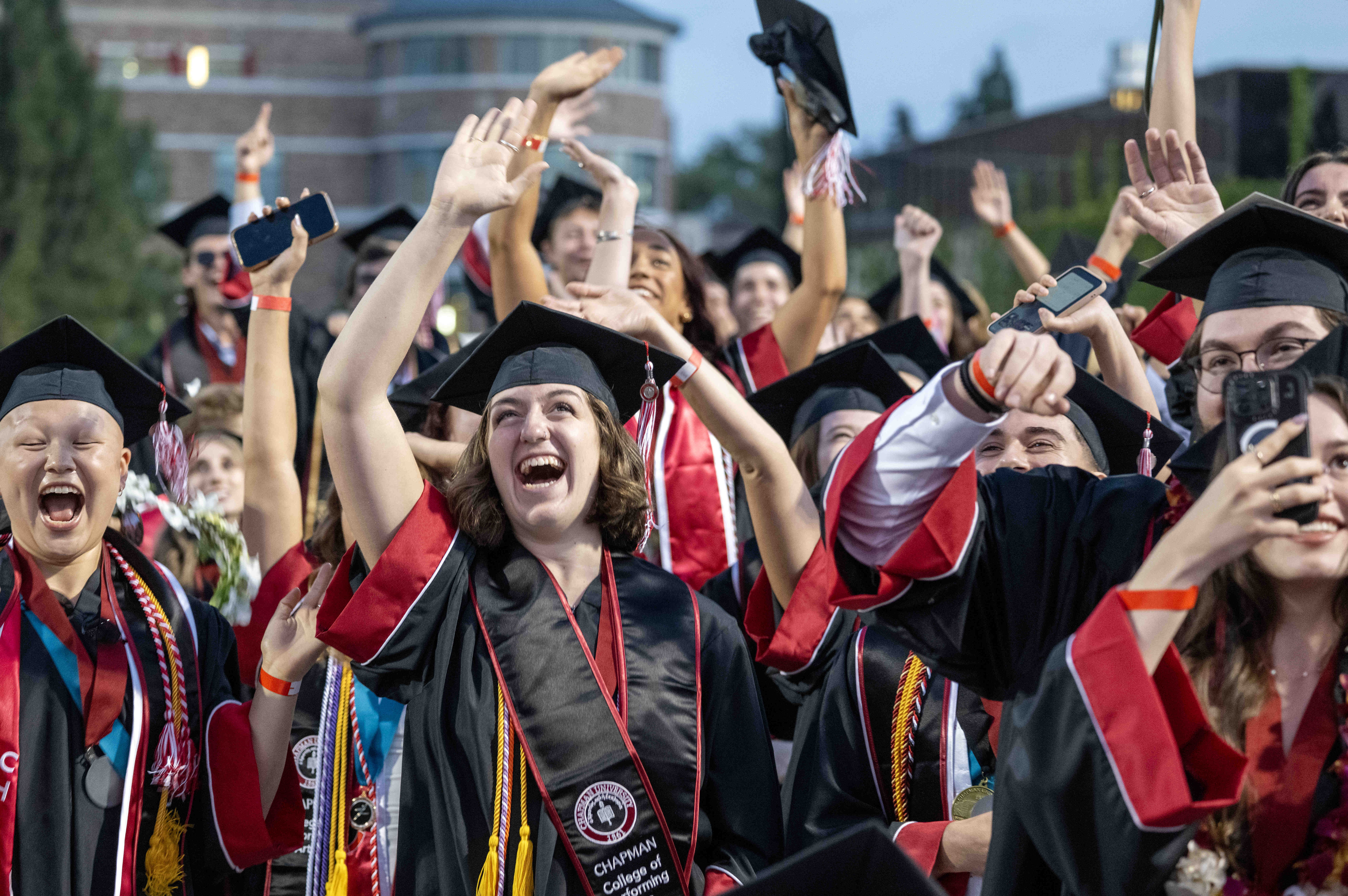 Chapman University graduates celebrate after moving their tassels and becoming...