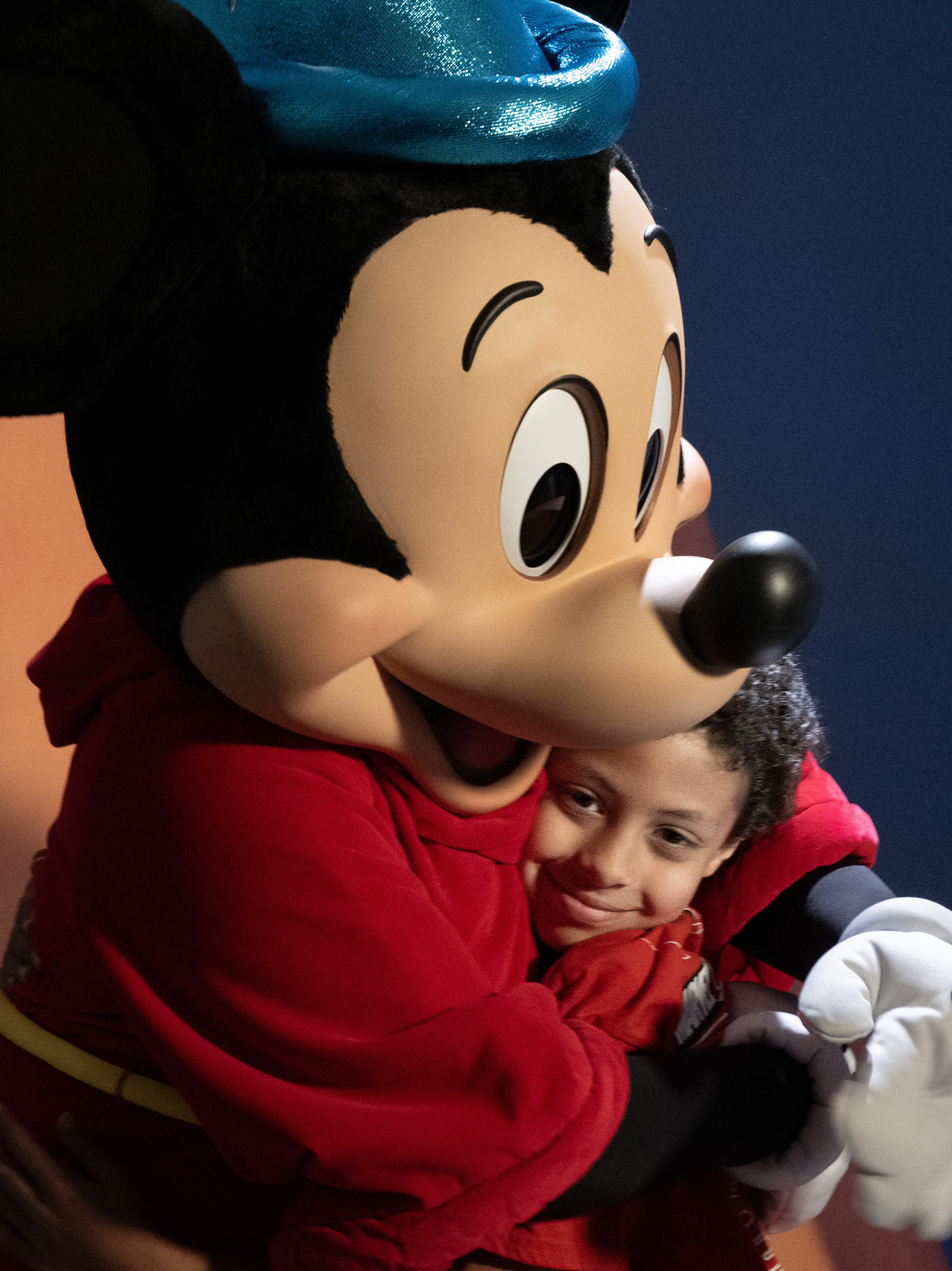 Eight-year-old Jordan Mosley gets a hug from Sorcerer Mickey on Wednesday,...