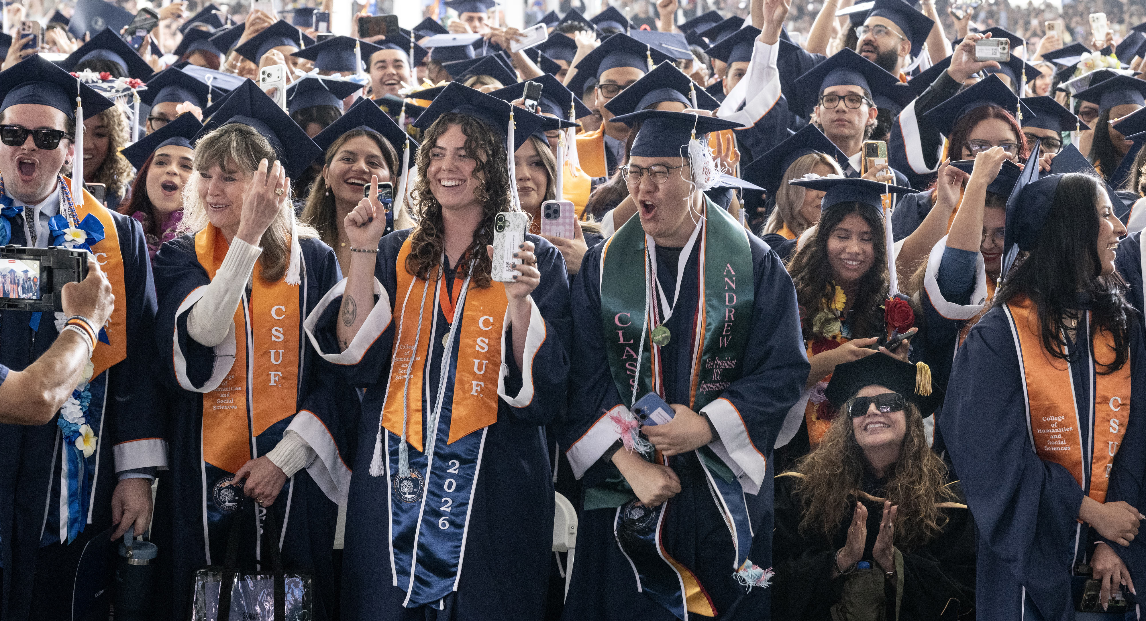 Students do the ceremonial tassel move — from the right...
