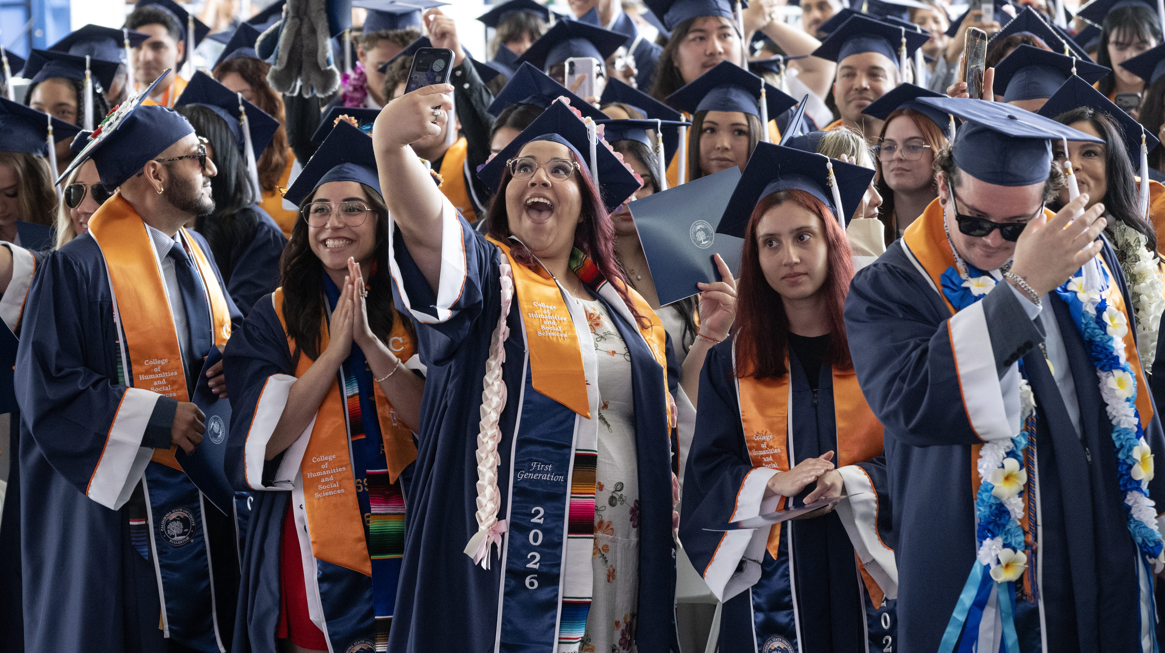 Students do the ceremonial tassel move — from the right...