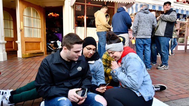 Kasey Angulo, right, cheers as she and her friends, Nick Knowles, left, Zachary Garcia, center, and Cade Clark get a boarding pass for Rise of the Resistance with the Disneyland app in Anaheim. (Photo by Jeff Gritchen, Orange County Register/SCNG)
