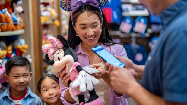 At select shops at Disneyland Resort, guests can scan and pay for items right from their phones using the Disneyland app. (Photo by Winston Suk, Disneyland Resort)