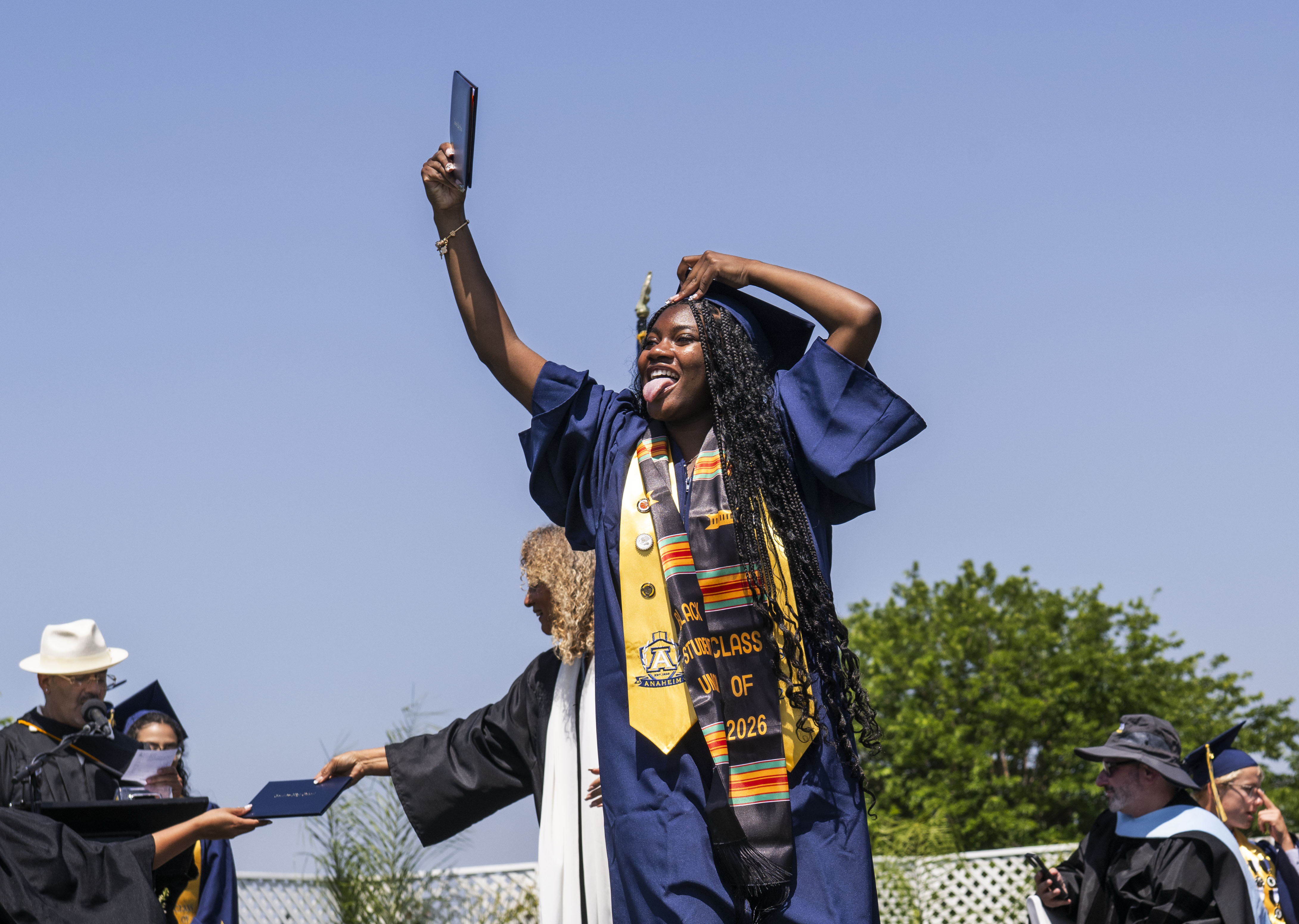 Mariella Jones shows off her diploma as she walks off...