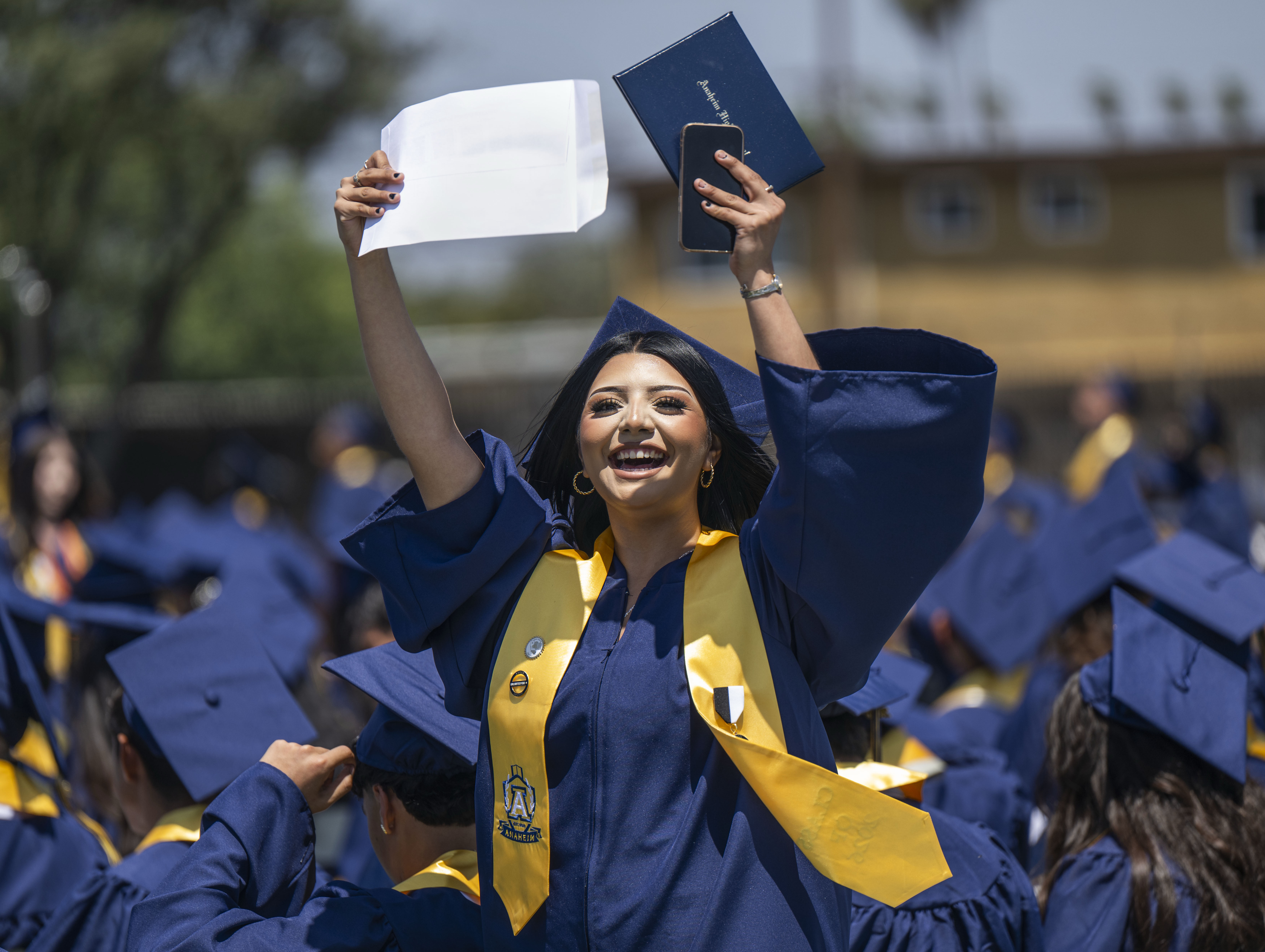 A proud Yahaira Sandoval waves her diploma in the air...
